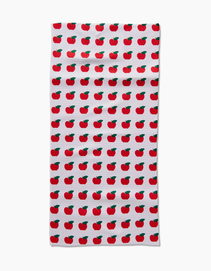The Apple Grove Bar Towel by Brittany Jepsen features a repeating red apple with green leaf pattern on white Geoweave fabric, known for its ultra-absorbency and even design coverage.