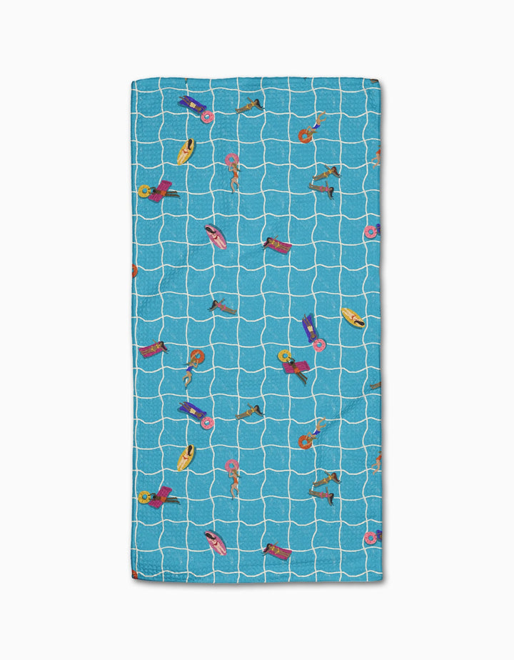 The At The Pool beach towel by Geometry features a rectangular blue Geoweave fabric with a white grid and colorful illustrations of people swimming and relaxing on pool floats.