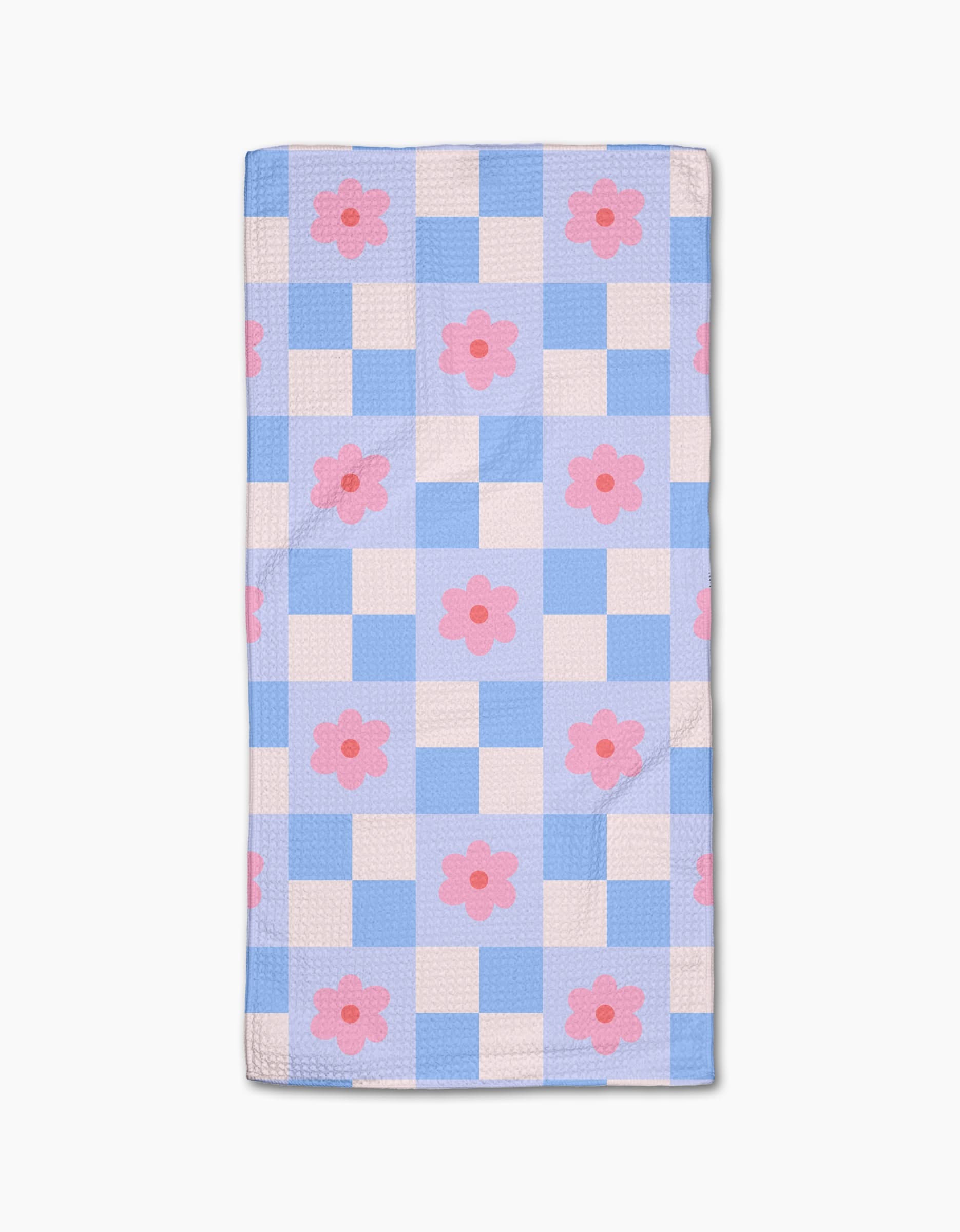 The Blue Checkered Florals quilt by Letters By Shells features a blue and white checkered pattern with evenly spaced pink flowers, crafted from recycled materials for an eco-friendly design.