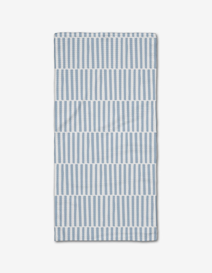 The Blue Stripes Bar Towel by Aubrey Fairchild features vertical blue and white stripes in horizontal bands on a white background, crafted from Geoweave fabric and neatly folded on a white surface.