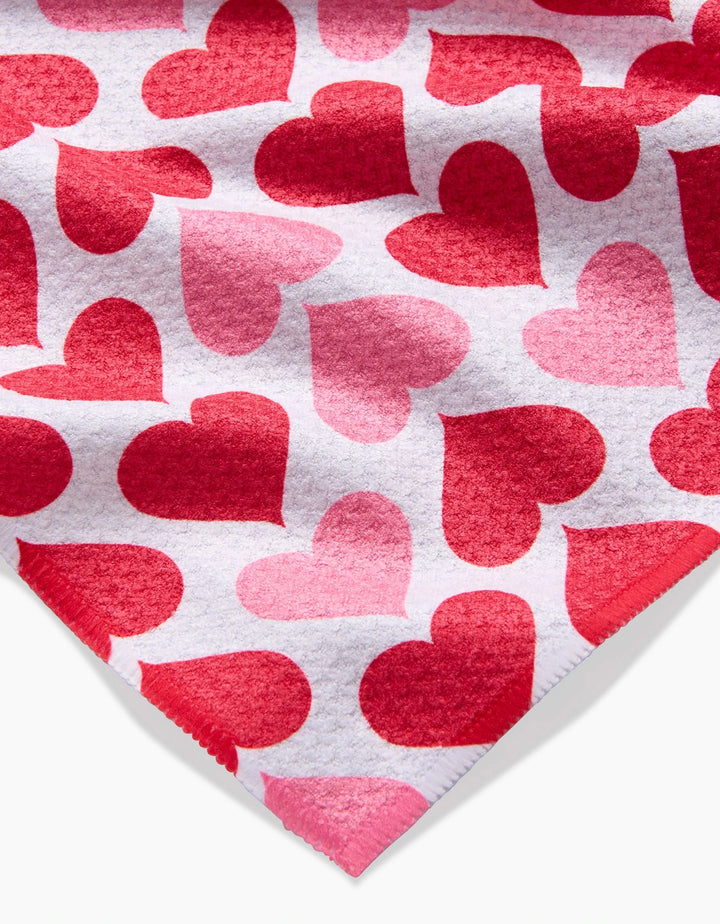 Blushing Hearts by Danelys Sidron: recycled fabric with overlapping red and pink hearts on white; fabric corner shown at bottom right.