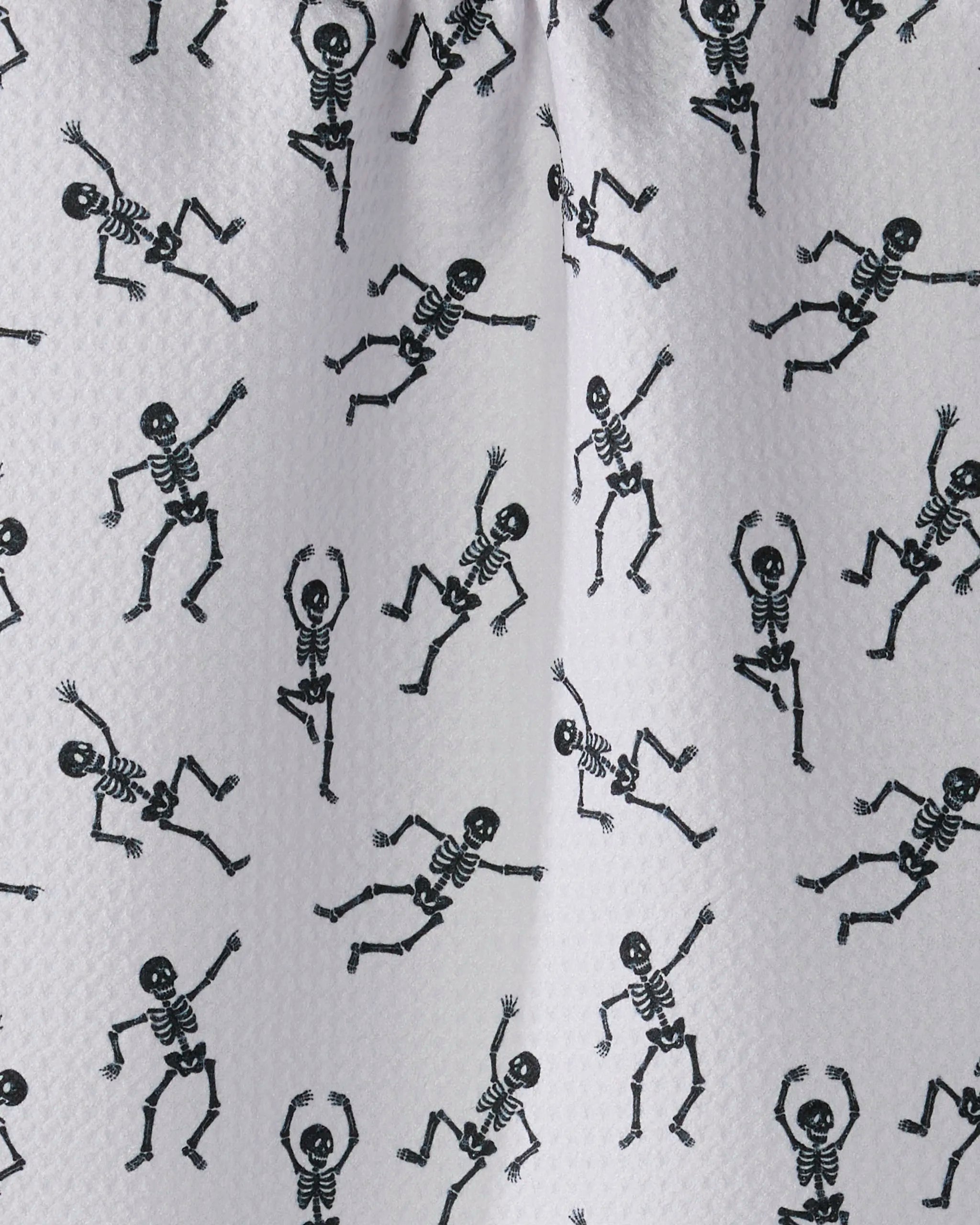 Bone Jamboree White by Geometry features playful black skeletons on white Geoweave fabric, creating a unique bar towel that adds fun to any space.