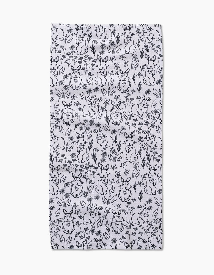 The Bunny Rabbit Garden by Charlie Rowan Designs is a white rectangular fabric with a close black line art pattern of rabbits, flowers, and leaves—ideal as a quick-drying towel for your kitchen or bar.