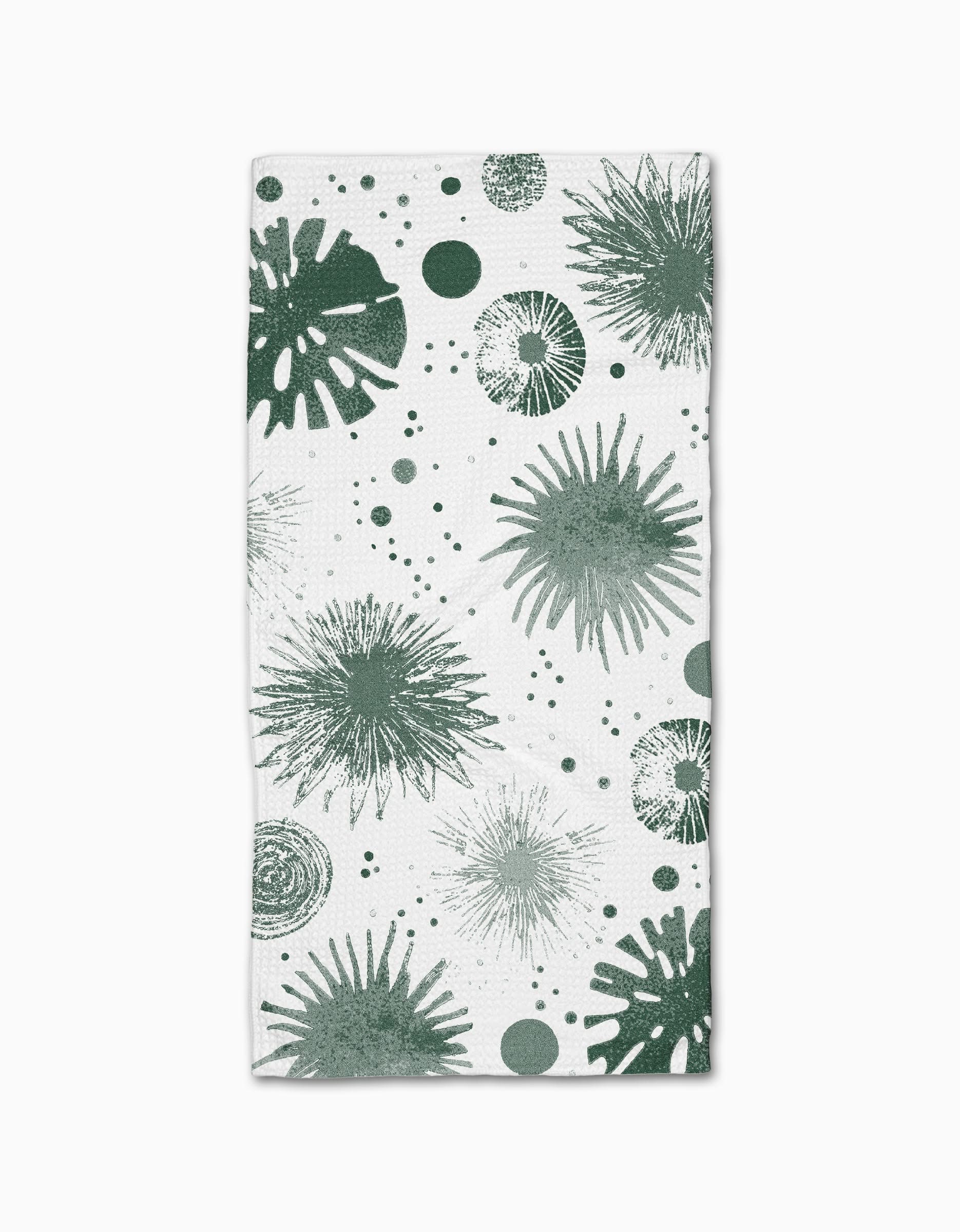 The Geometry Bursting Skies Green is a white rectangular bar towel, made from recycled materials, featuring playful green abstract sea urchins and dotted shapes for a marine-inspired look.