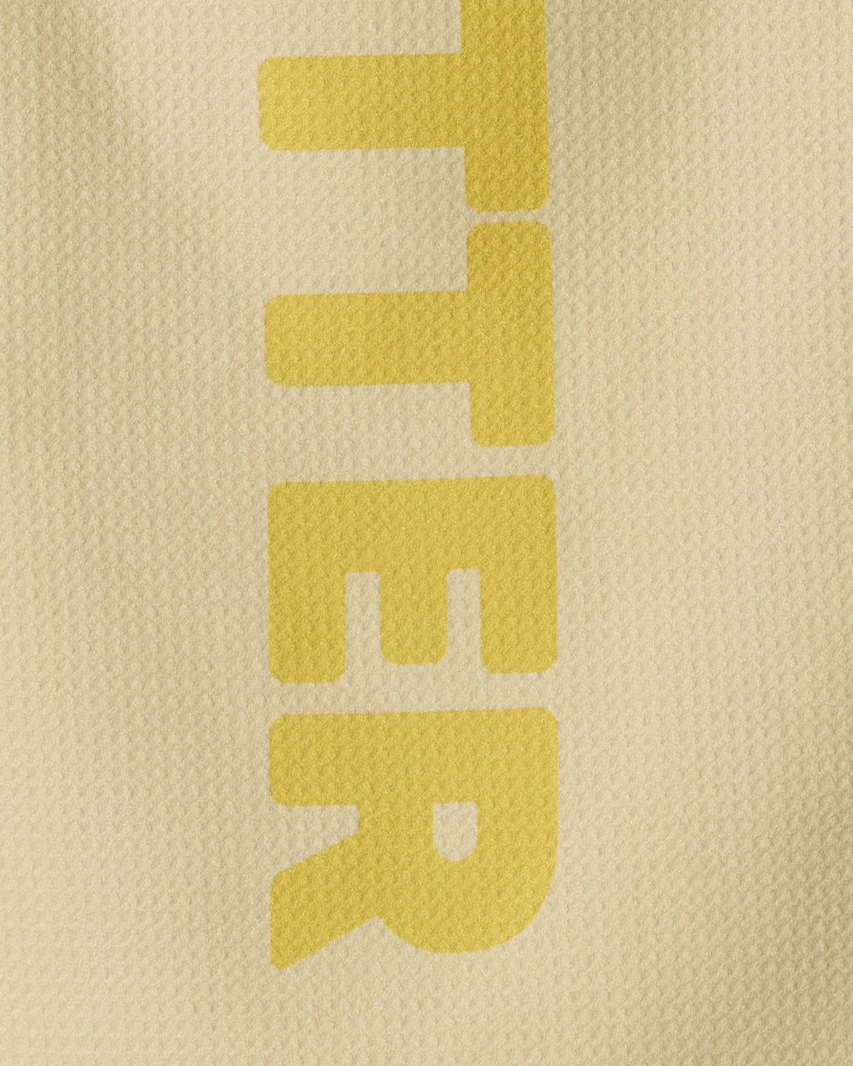 The word Butter printed vertically in large, yellow, sans-serif letters on a textured, tan Geoweave fabric.