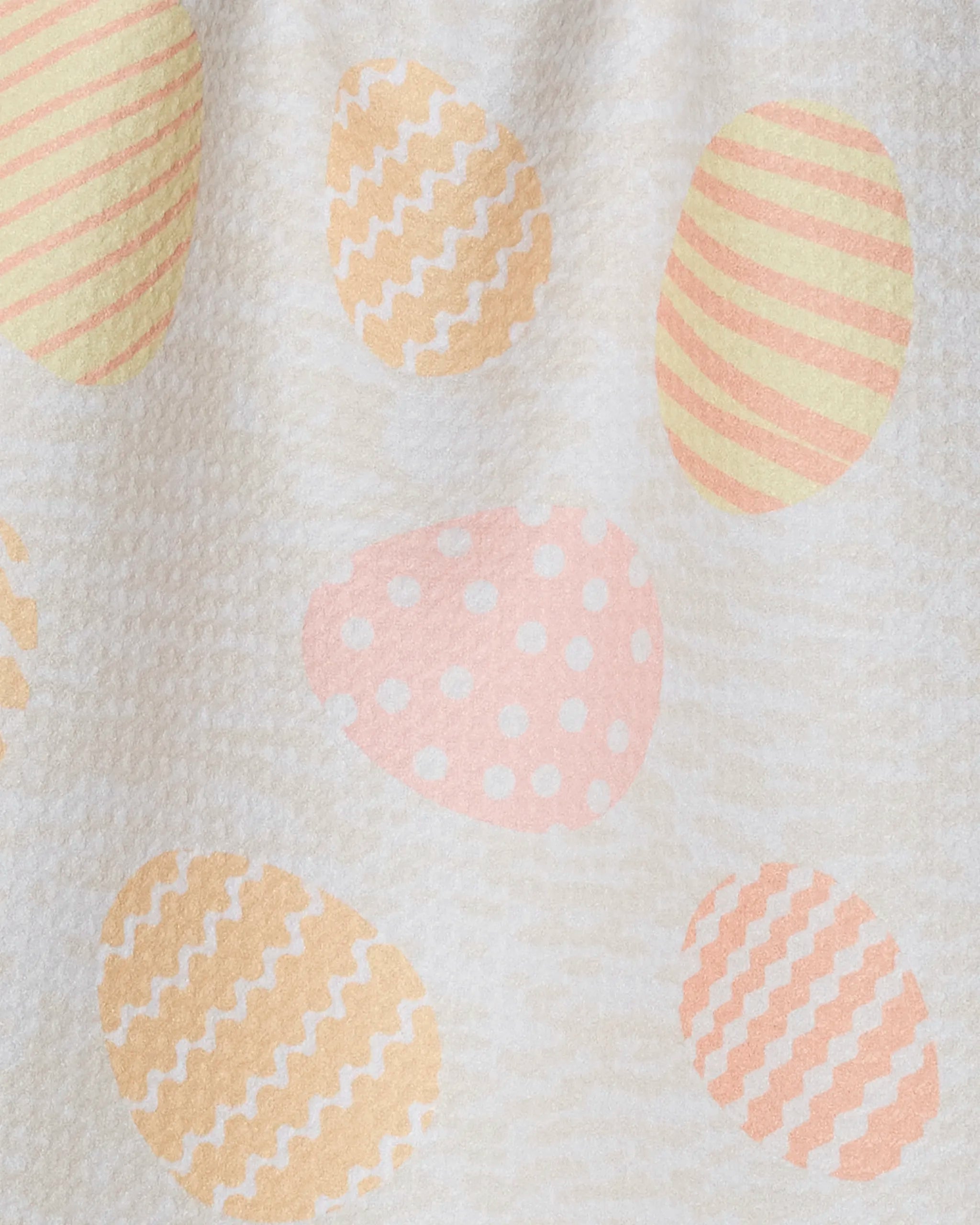 The Geometry Buttercream Easter bar towel features quick-drying fabric and a pastel pattern of yellow, pink, and orange Easter eggs with stripes, dots, or zigzags on a light textured background.