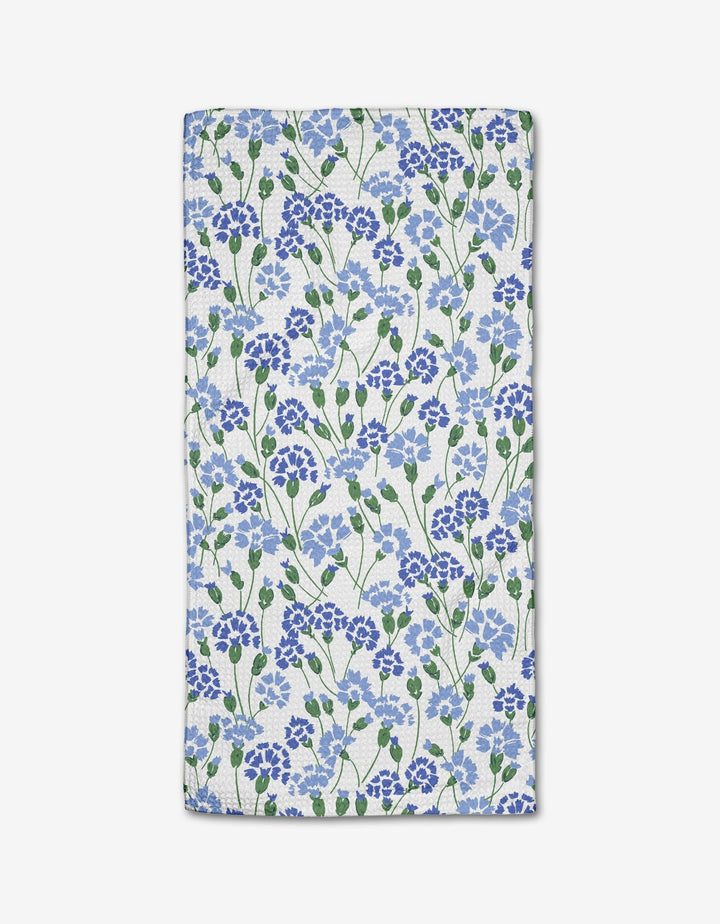 The Carnation Fields Bar Towel by Hufton Studio features a dense blue and purple floral pattern with green leaves on white Geoweave fabric.