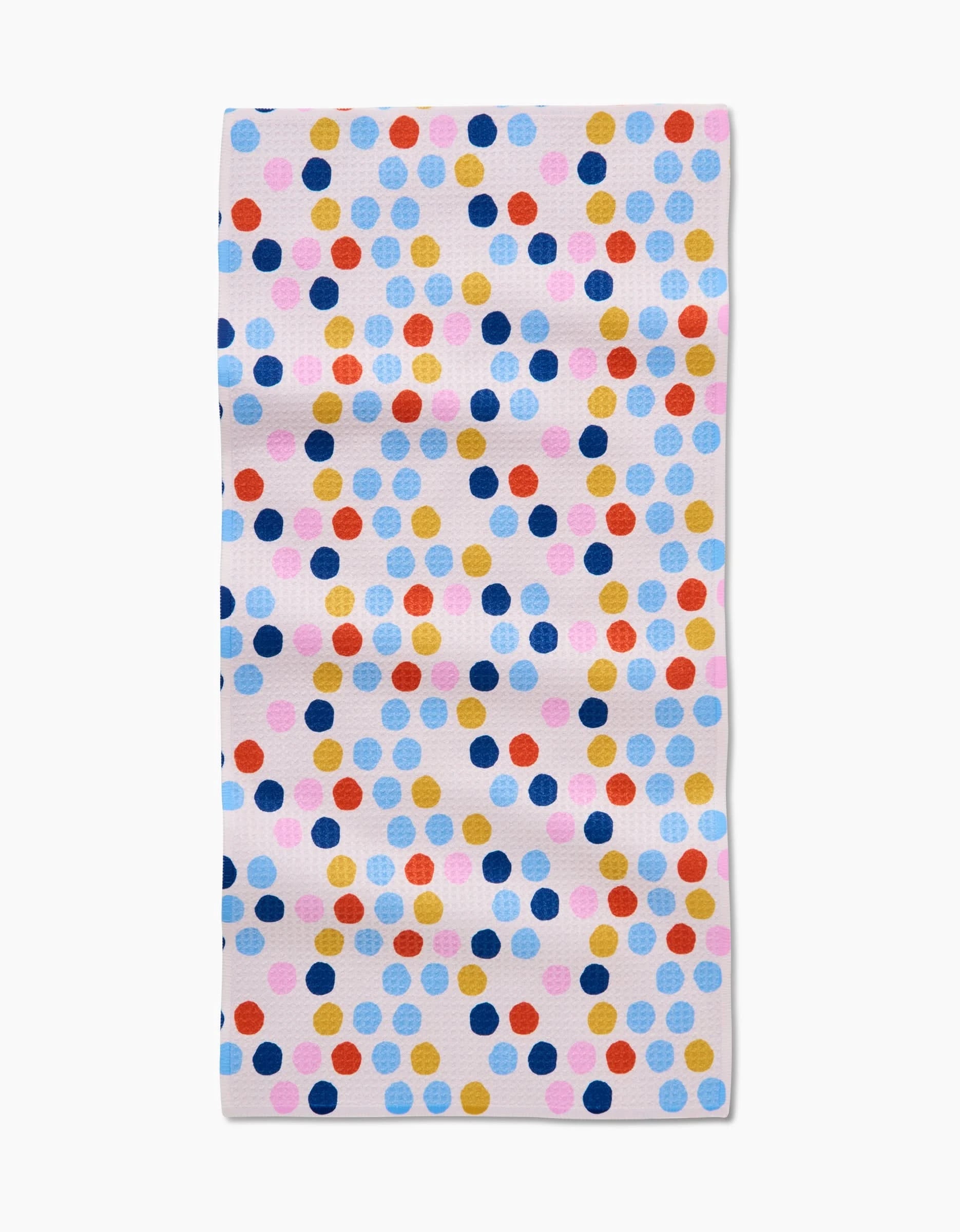 The Lizzie Clark Carnival Bar Towel features a white background with evenly spaced colorful polka dots in blue, pink, yellow, red, and orange. Made of soft Geoweave fabric for extra absorbency.