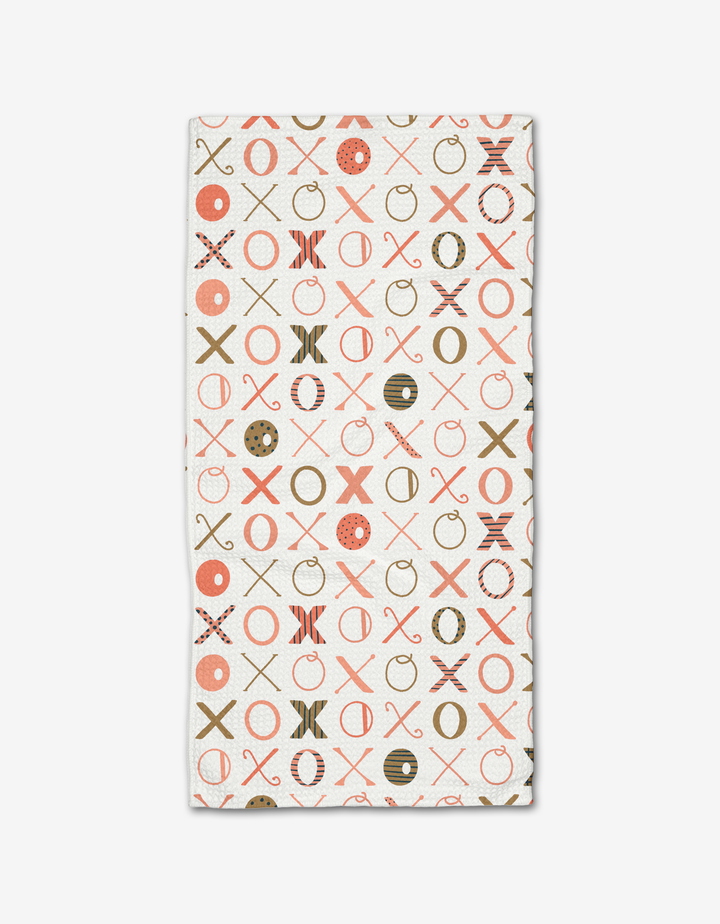 The Carys Light rectangular bar towel by Amy MacCready is made from recycled Geoweave fabric and showcases a repeating X and O pattern in red, brown, and beige on white for stylish sustainability.