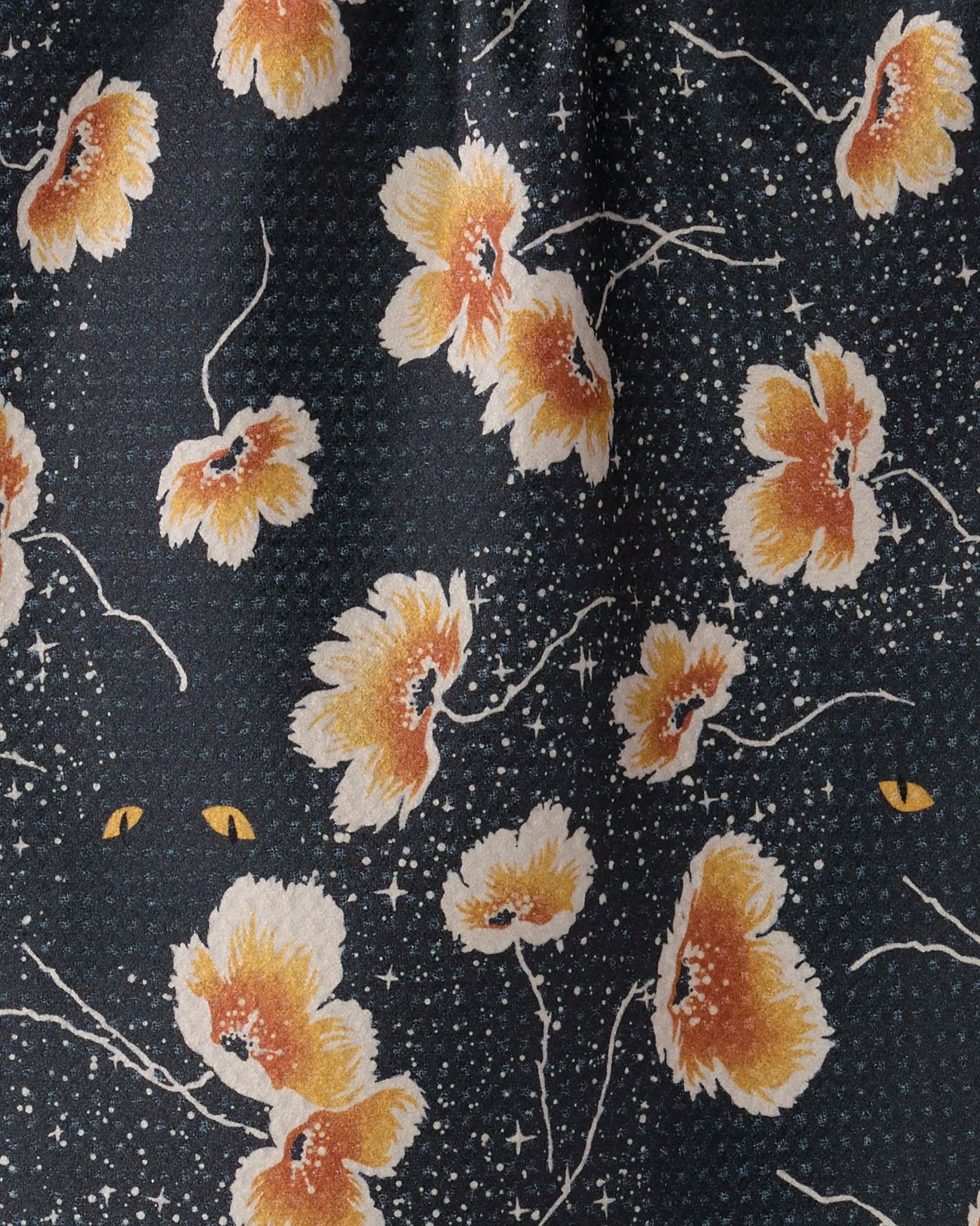 The Geometry Cats Eye towel features dark fabric with yellow and white flowers, scattered white star-like dots, and two hidden yellow cat eyes for a whimsical touch—a stylish, quick-drying choice for your kitchen or bar.