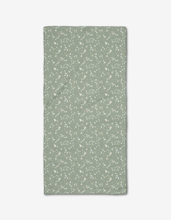 The Chamomille Terrazzo Bar Towel by Second Nature Studio is rectangular, light green Geoweave fabric with a subtle white floral pattern, shown laid flat on a white background.