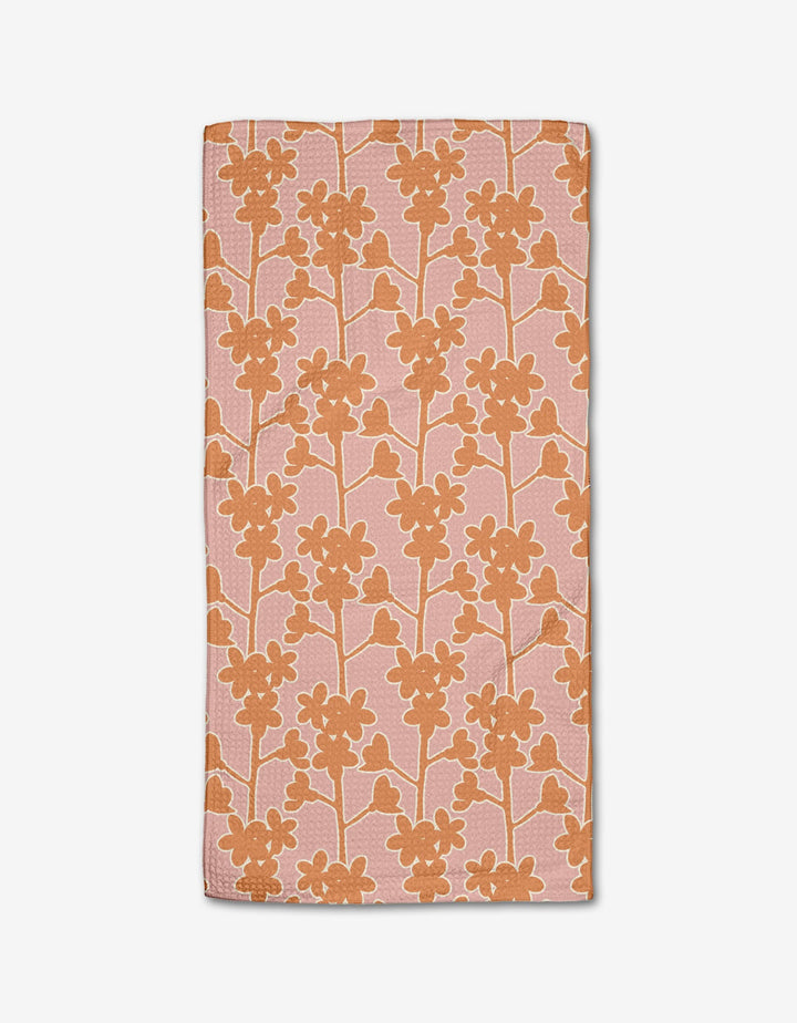 The Cherry Blossom Branches bar towel by Lizzie Clark features a rectangular pink design with an orange floral pattern, made from Geoweave fabric and recycled materials, shown on a white background.