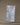 The Geometry Cool Dots recycled kitchen towel, white and rectangular with blue, grey, and black dot patterns, hangs from a string by two wooden clothespins against a simple background.