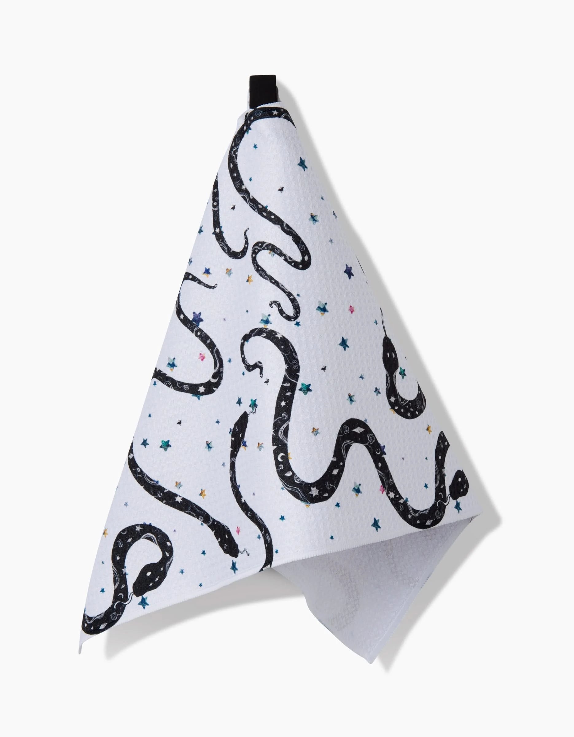 The Cosmic Snakes Bar Towel by Pascale Dilger, crafted from Geoweave™ fabric, has a black snake design with colorful stars on white and hangs gracefully from a black loop.