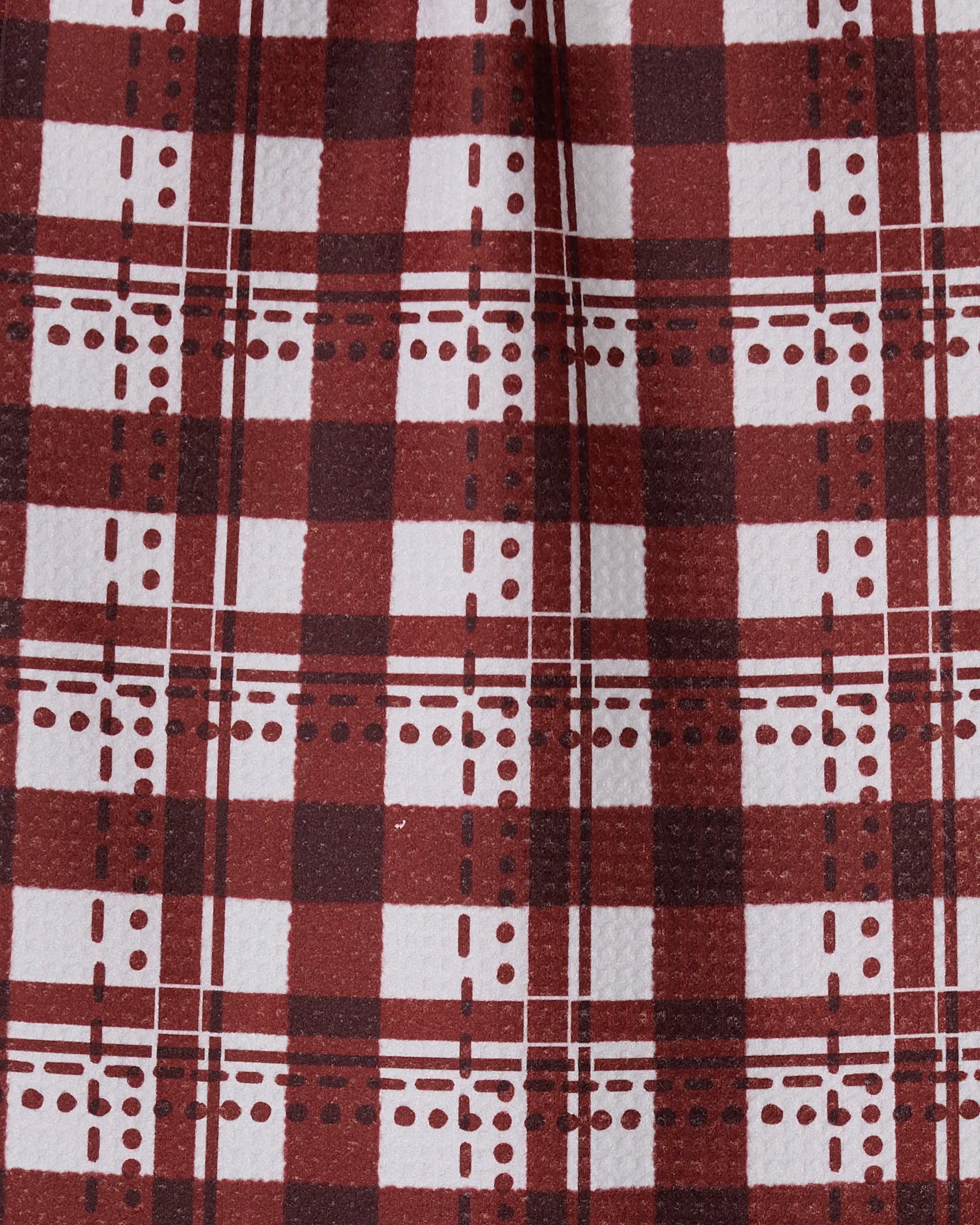 The Geometry Cranberry Plaid bar towel features a red and white plaid pattern with intersecting lines and dots. Made from recycled materials, this ultra-absorbent towel has a slightly textured look and a center vertical fold.
