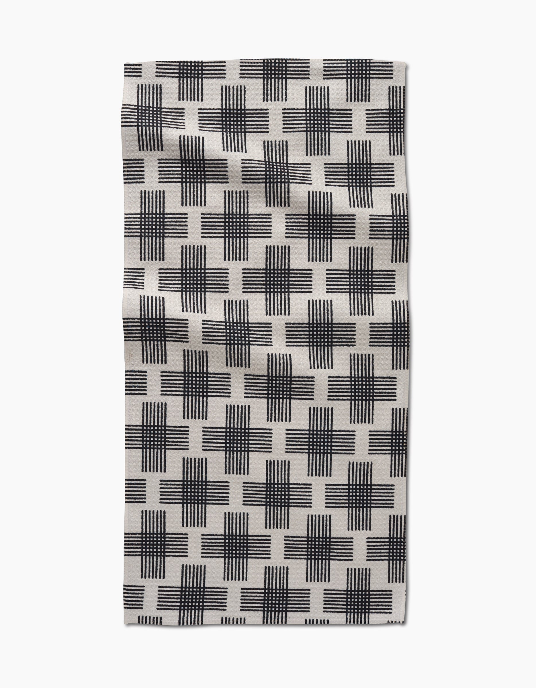 The Cross Hatch bar towel by Rosa Kichline features black and white overlapping grid-like squares on Geoweave fabric, shown flat against a white background.