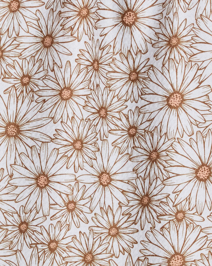 Close-up of Geometry’s “Daisy Trail” fabric, featuring a lively, detailed floral design with brown-outlined daisies and leaves on white—perfect for an absorbent, quick-dry towel.