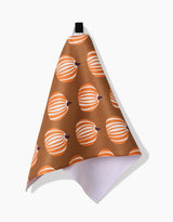 The Dancing Pumpkins bar towel by Lizzie Clark features an orange and white pumpkin pattern on brown Geoweave fabric, hangs from a black loop, and has a white reverse side.