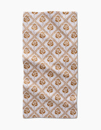 The Dancing Vines kitchen towel by Charlie Rowan Designs is a rectangular white recycled towel with a brown floral and leaf diamond pattern. Its symmetrical design brings charm and function to this ultra-absorbent kitchen essential.