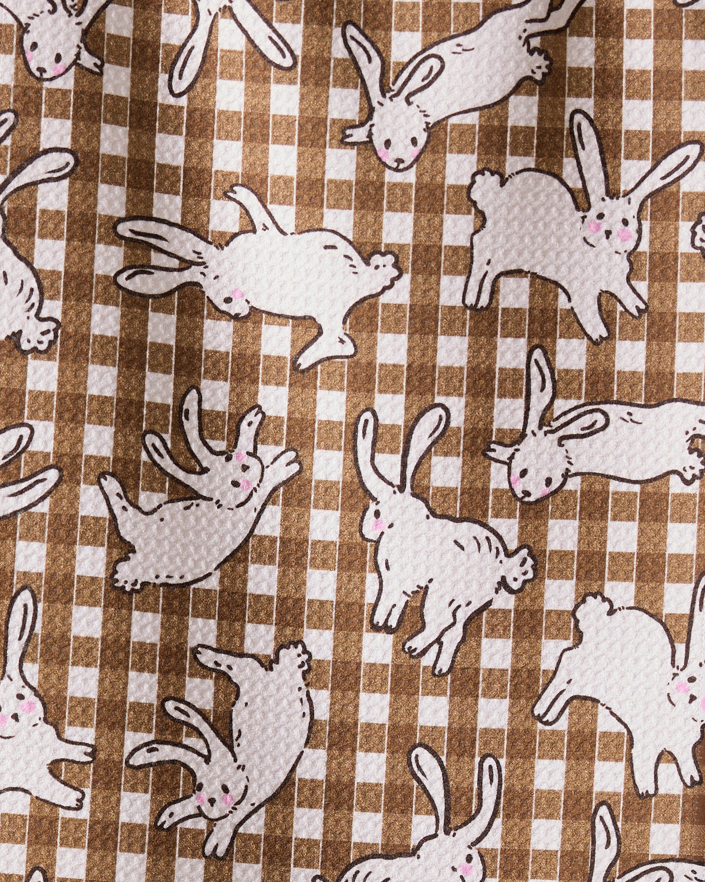 The Geometry Fall Bunny Hops towel features ultra-absorbent fabric with white cartoon rabbits, pink noses, and black outlines scattered on a brown and white checkered background—adding playful charm to any kitchen.
