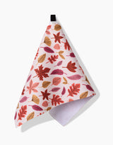 The Kayla Ann Fall Leaves Bar Towel is white with a hanging loop, made from recycled materials, and features a colorful autumn leaf pattern in red, orange, and gold. It is shown against a plain white background.