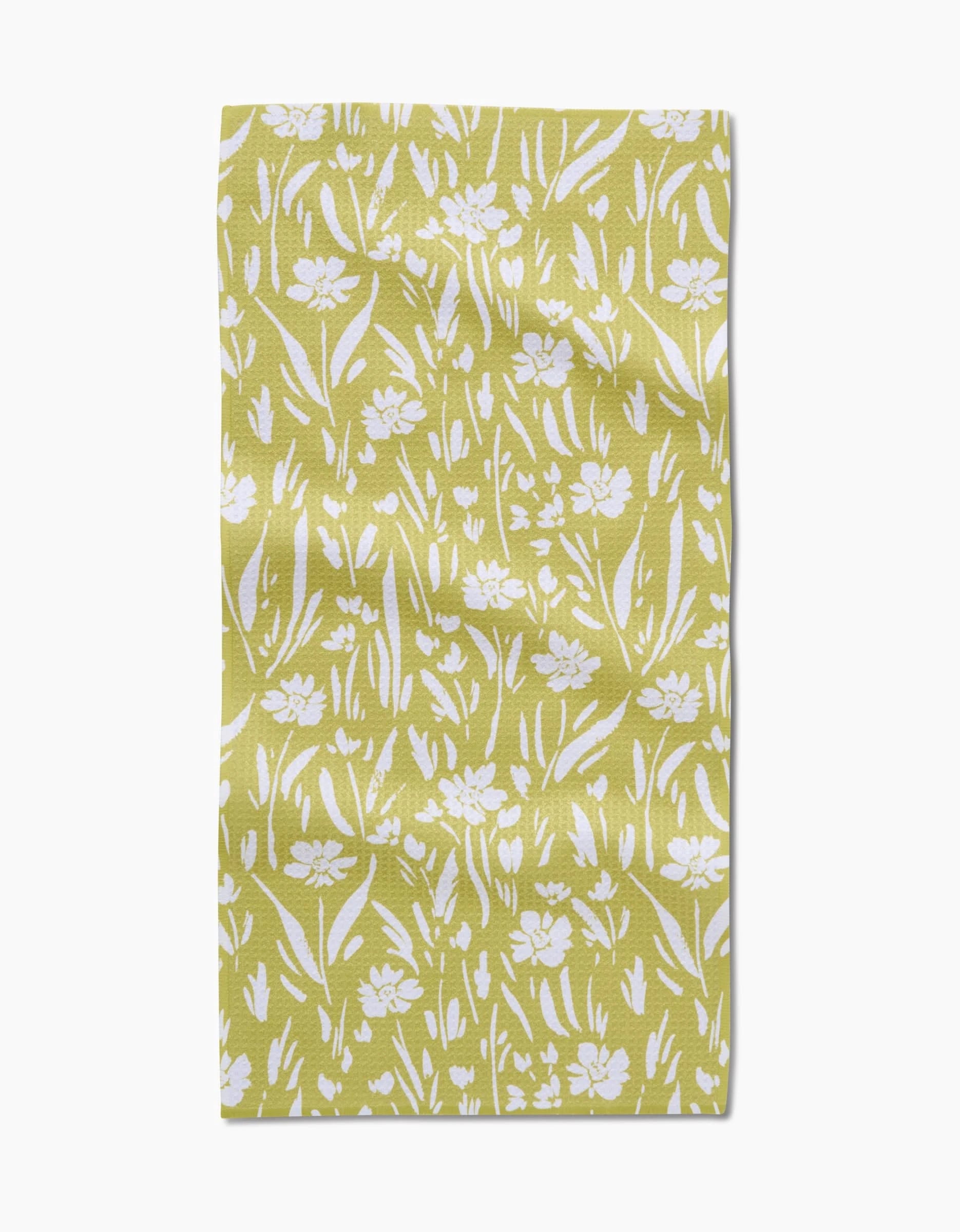 The Ashley Celena Field of Wildflowers Bar Towel is a yellow rectangular towel with a white floral and leaf pattern in various sizes on textured Geoweave fabric for a natural, slightly wrinkled look.