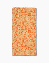 Florence by Katie OShea is an orange rectangular recycled kitchen towel featuring a light tan floral and leafy pattern throughout and slightly uneven edges for a handcrafted appearance.