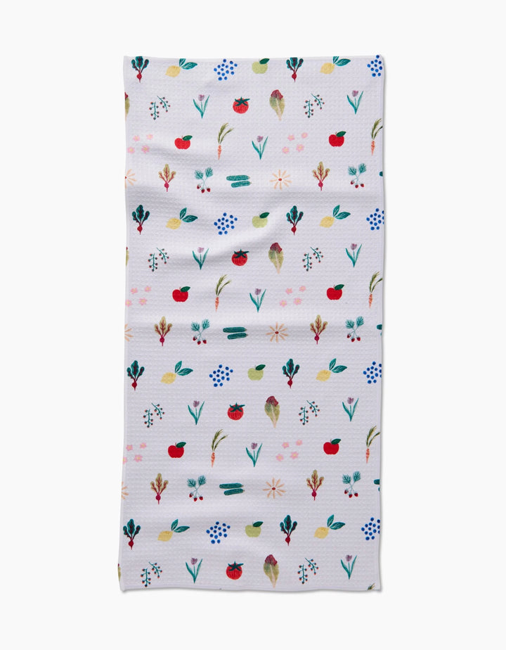 The Fresh Produce Geoweave cloth by Brittany Jepsen is a rectangular, ultra-absorbent white towel adorned with colorful, hand-painted flowers, leaves, and red fruits arranged in horizontal rows.