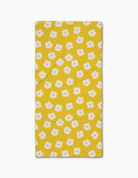 The Sara Mari Garden Crush Bar Towel is yellow and rectangular, featuring a Geoweave fabric with small white flowers with orange centers evenly spaced across the surface.