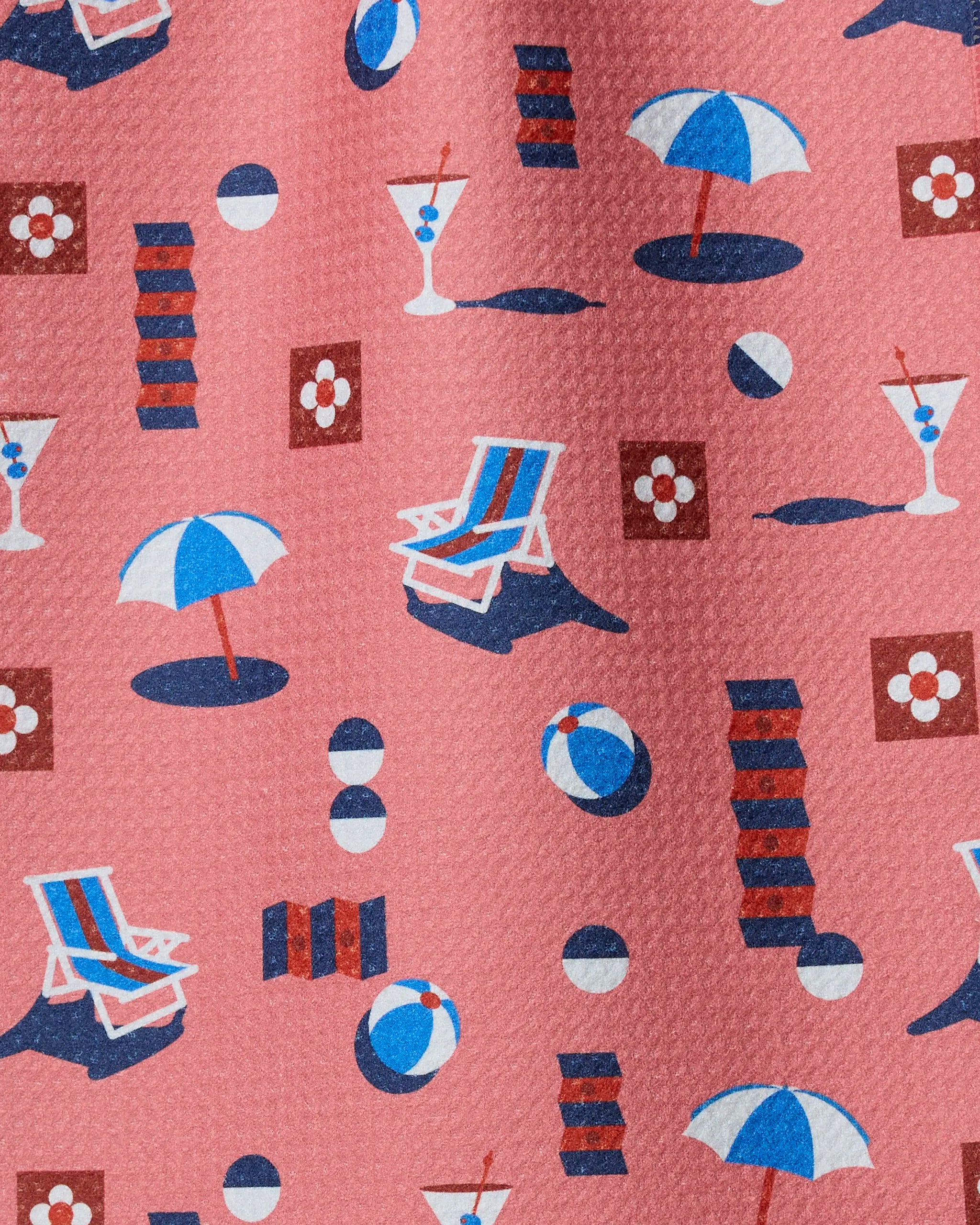 Geo Beach Day by Geometry features patterned fabric made from recycled materials with beach umbrella, lounge chair, ball, drink, and floral illustrations on a pink background—perfect for ultra-absorbent or stylish bar towels.