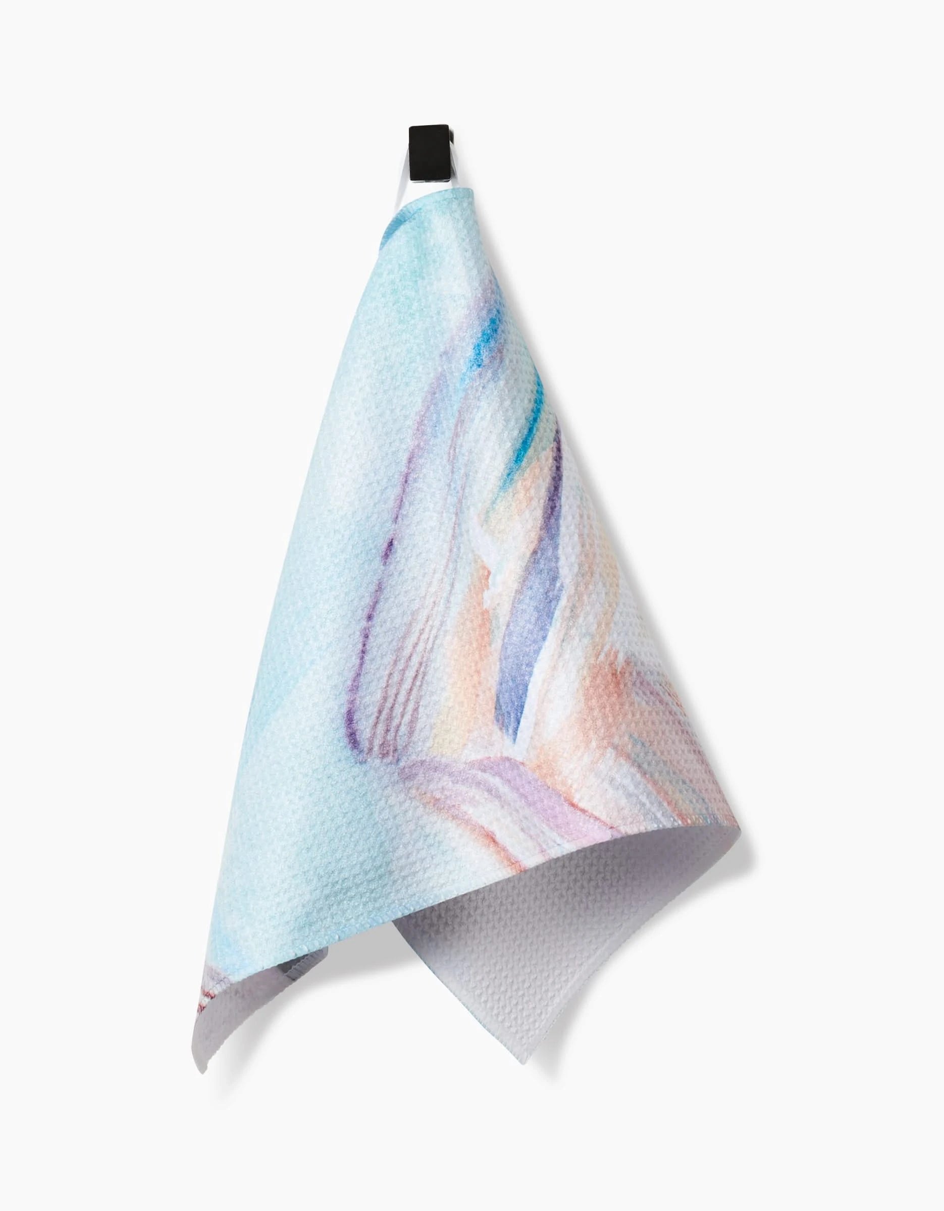 The Golden Hour in the Rockies bar towel by Kelly Peters features textured Geoweave fabric with a pastel watercolor design in blue, pink, and purple, and hangs from a black loop against a white background.