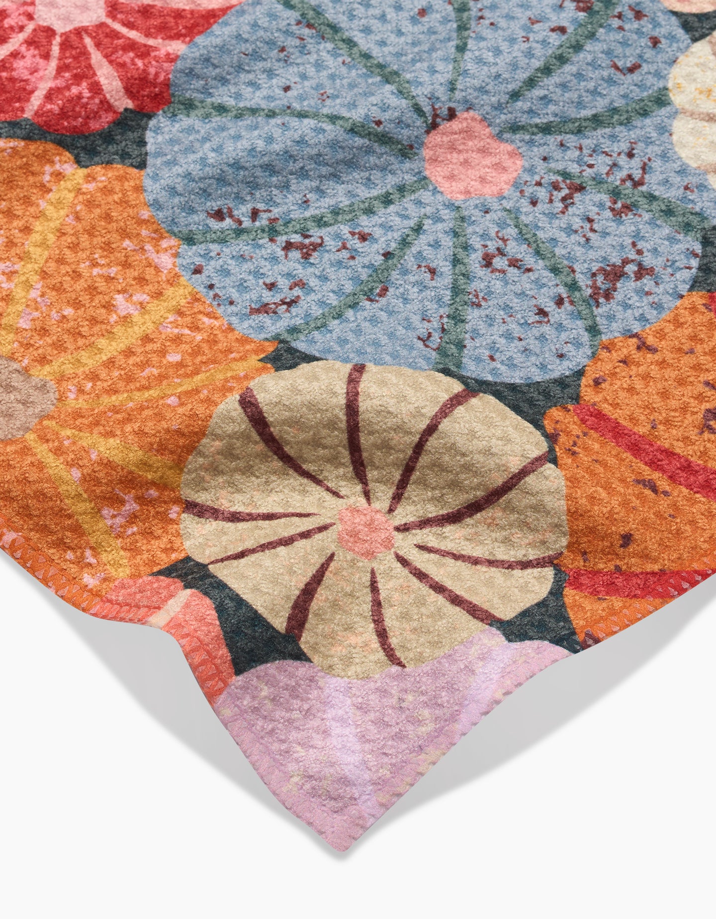 The Gorgeous Gourds bar towel by Rebecca Bobko features large, overlapping flowers in blue, orange, cream, red, and purple. Made from recycled materials, it has a textured, slightly distressed finish for a unique look.