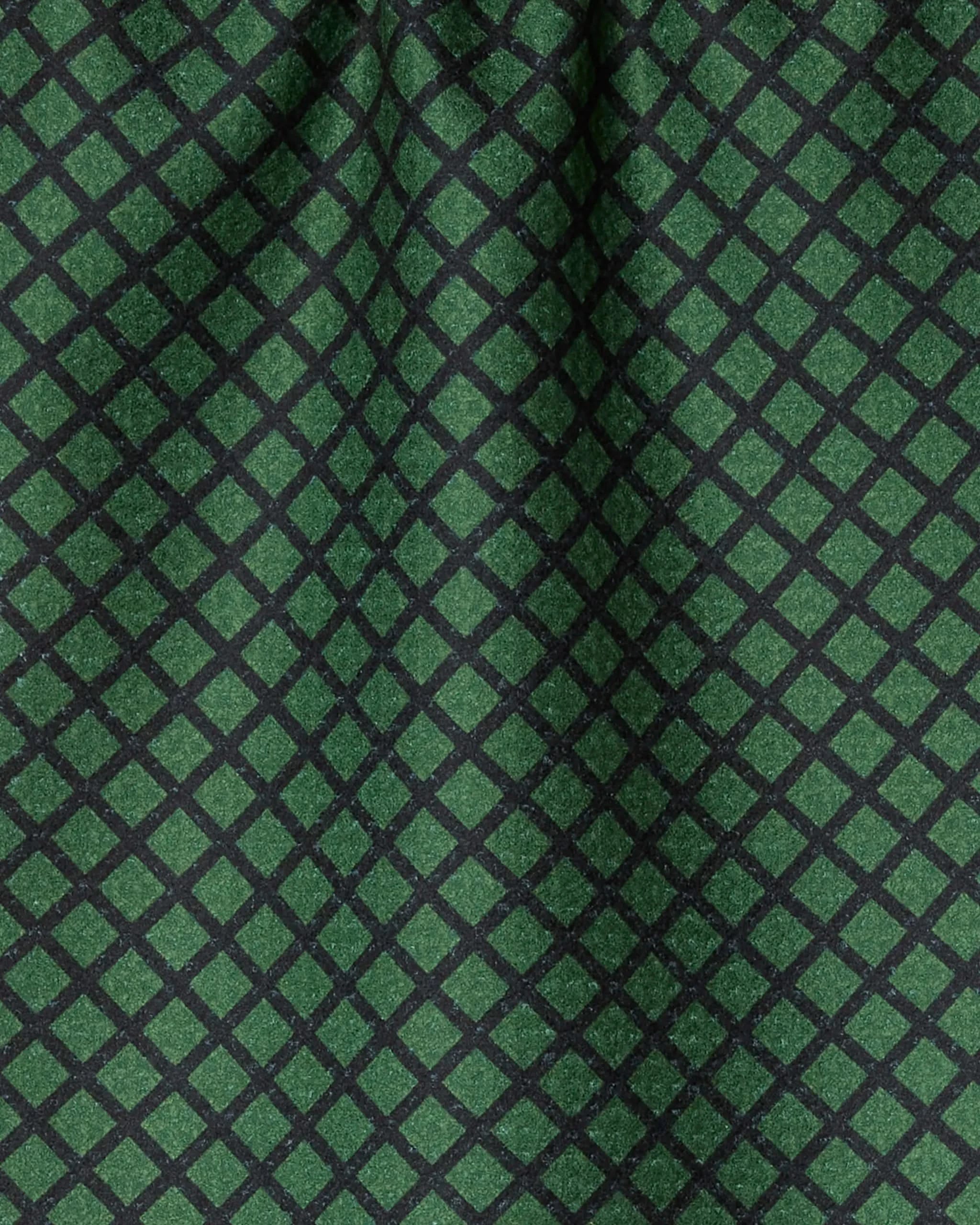 The Geometry Green Lattice features a repeating diamond-shaped black grid on green fabric, with gentle folds adding texture and shadow—combining ultra-absorbent performance with stylish design.