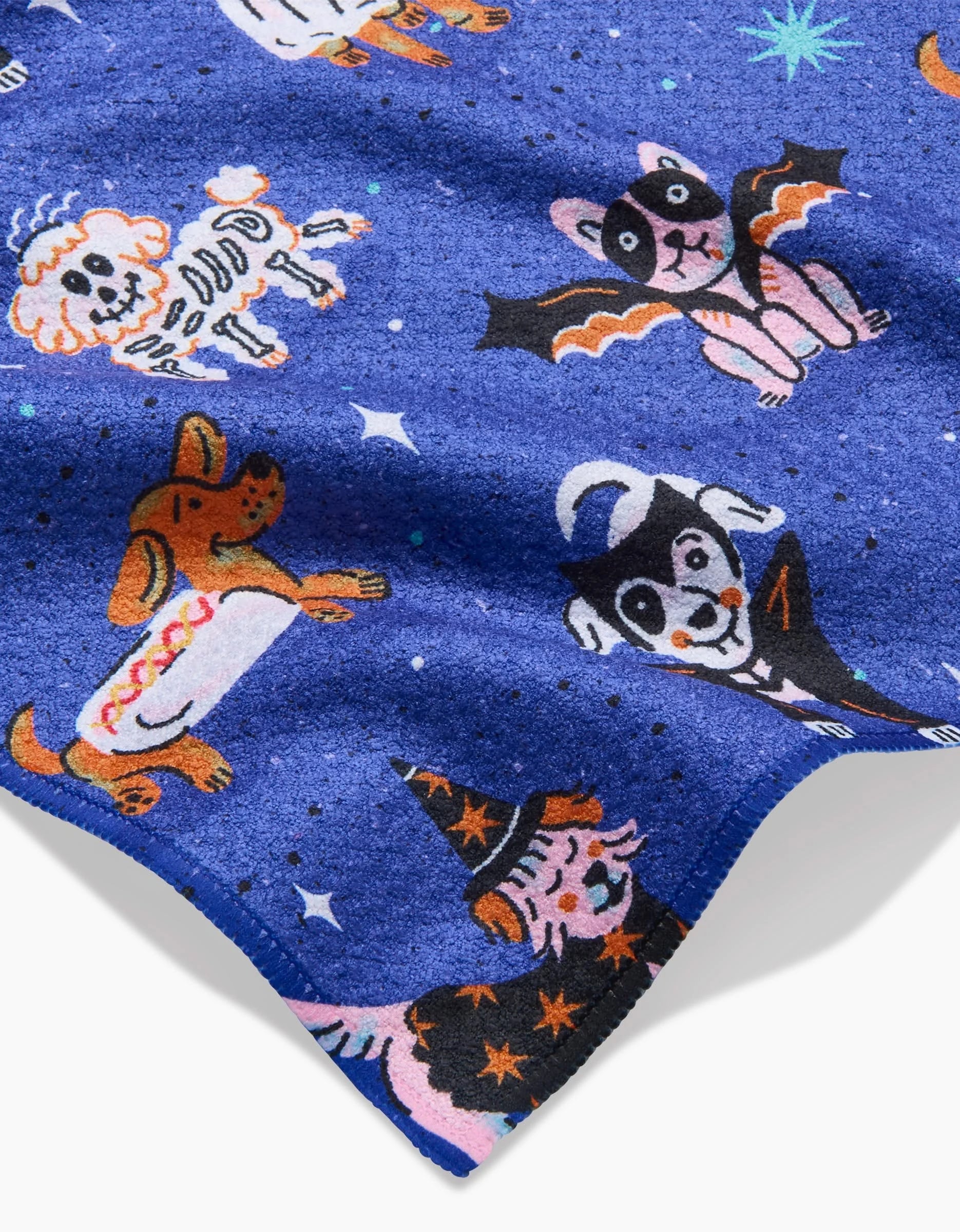 The Halloween Hounds Bar Towel by Camila Leão features cartoon dogs in Halloween costumes—skeleton, bat, ghost, hot dog, witch—amid stars and dots on soft Geoweave™ fabric made from recycled materials.