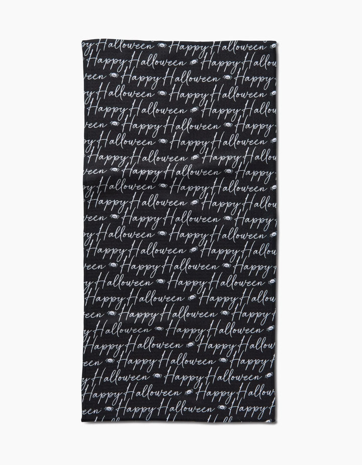 The Geometry Halloween Script Black towel is a black rectangular bar towel with “Happy Halloween” written repeatedly in white cursive across its surface.