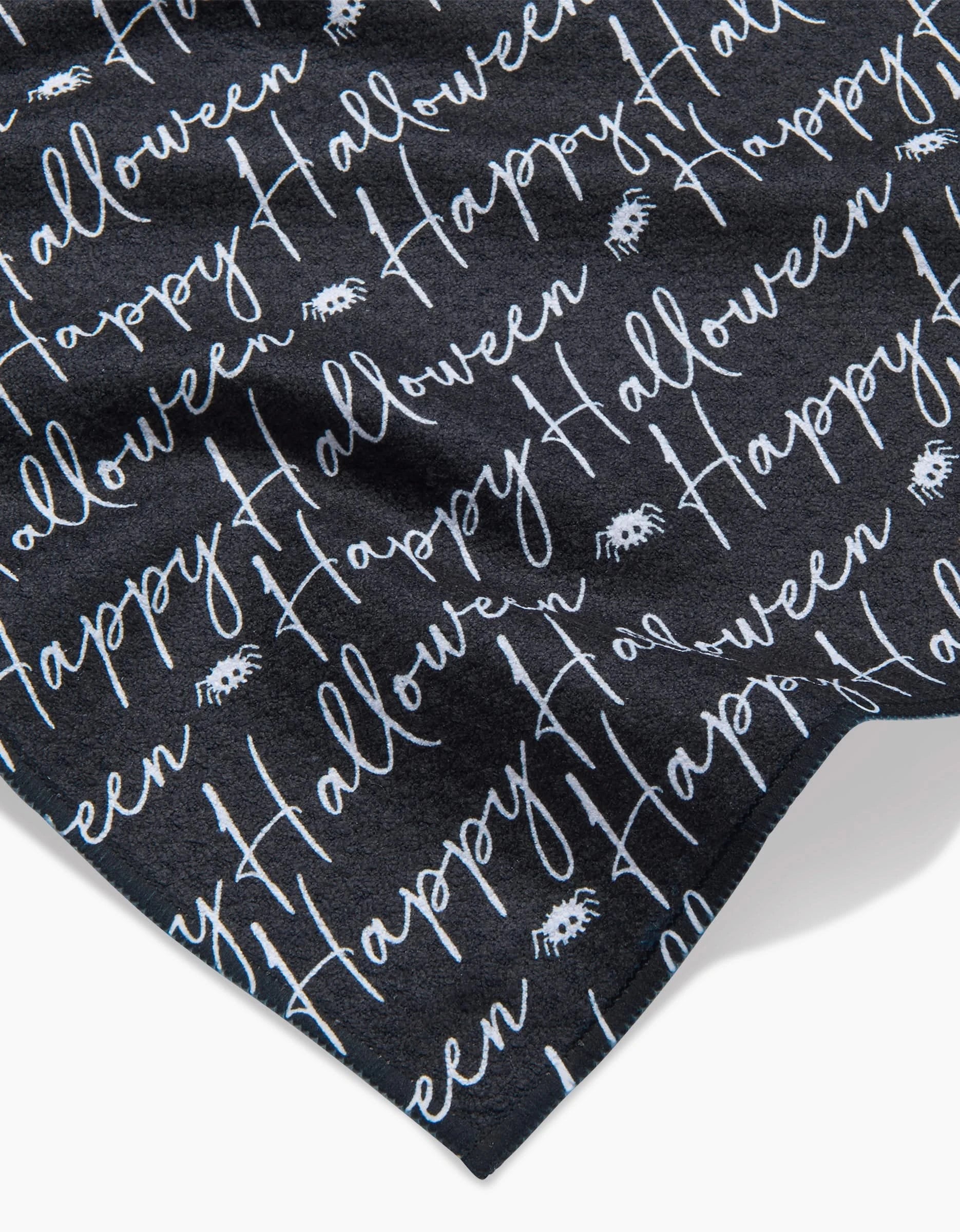 The Geometry Halloween Script Black bar towel features white cursive Happy Halloween text and spider graphics on black, made from ultra-absorbent recycled materials for eco-friendly style and function.