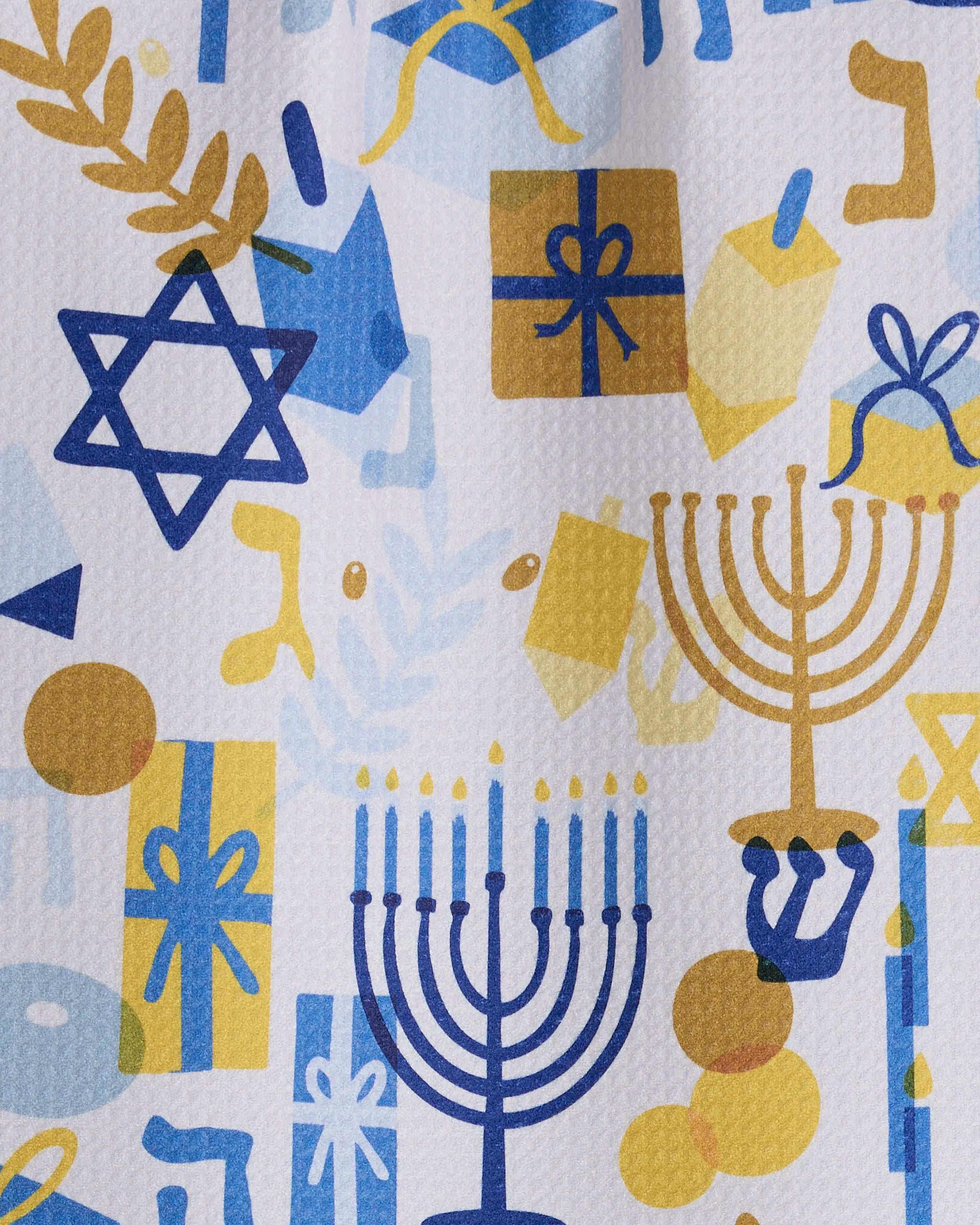 Add festive flair to your Hanukkah with Geometry’s "Hanukkah is Here" bar towel, featuring blue and gold menorahs, dreidels, gift boxes, and Stars of David on ultra-absorbent recycled fabric.