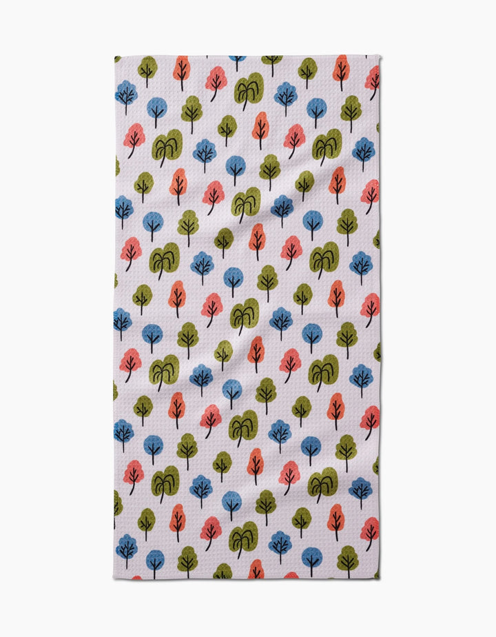 The Kayla Ann Happy Trees Bar Towel features a repeating pattern of small, stylized blue, green, and orange trees on white Geoweave fabric.