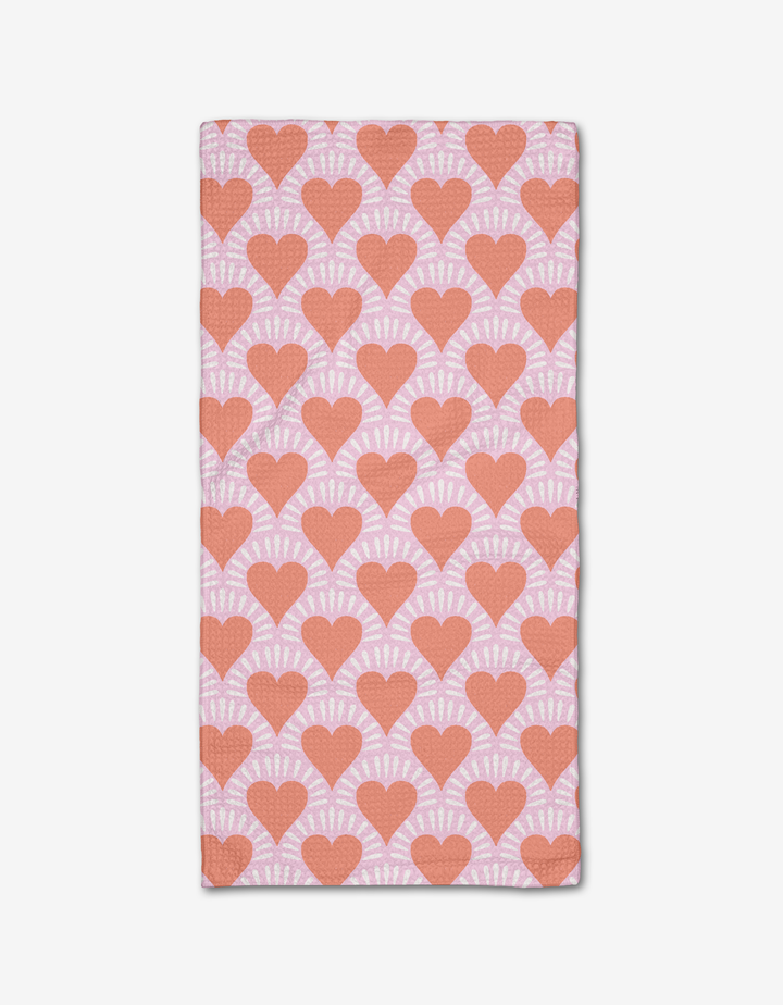 The Heartthrob bar towel by Charlie Rowan Designs features a light pink Geoweave fabric with evenly spaced red hearts outlined in white rays, creating a bold all-over pattern.