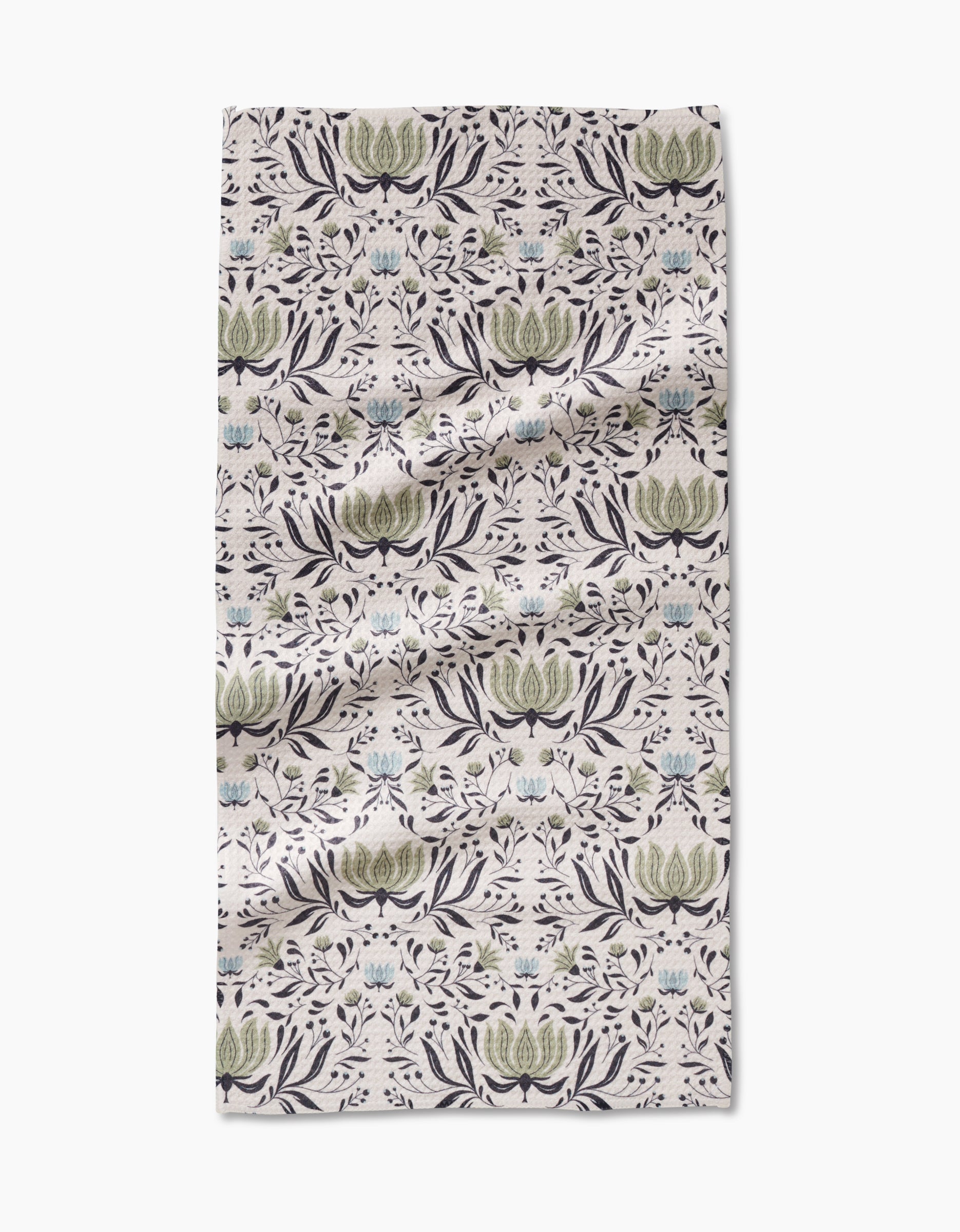 The Hello Flowers Bar Towel by Amita Nair is crafted from ultra-absorbent Geoweave fabric, featuring a green, blue, and black floral pattern on light beige. Rectangular with light wrinkles, its shown on a white surface.