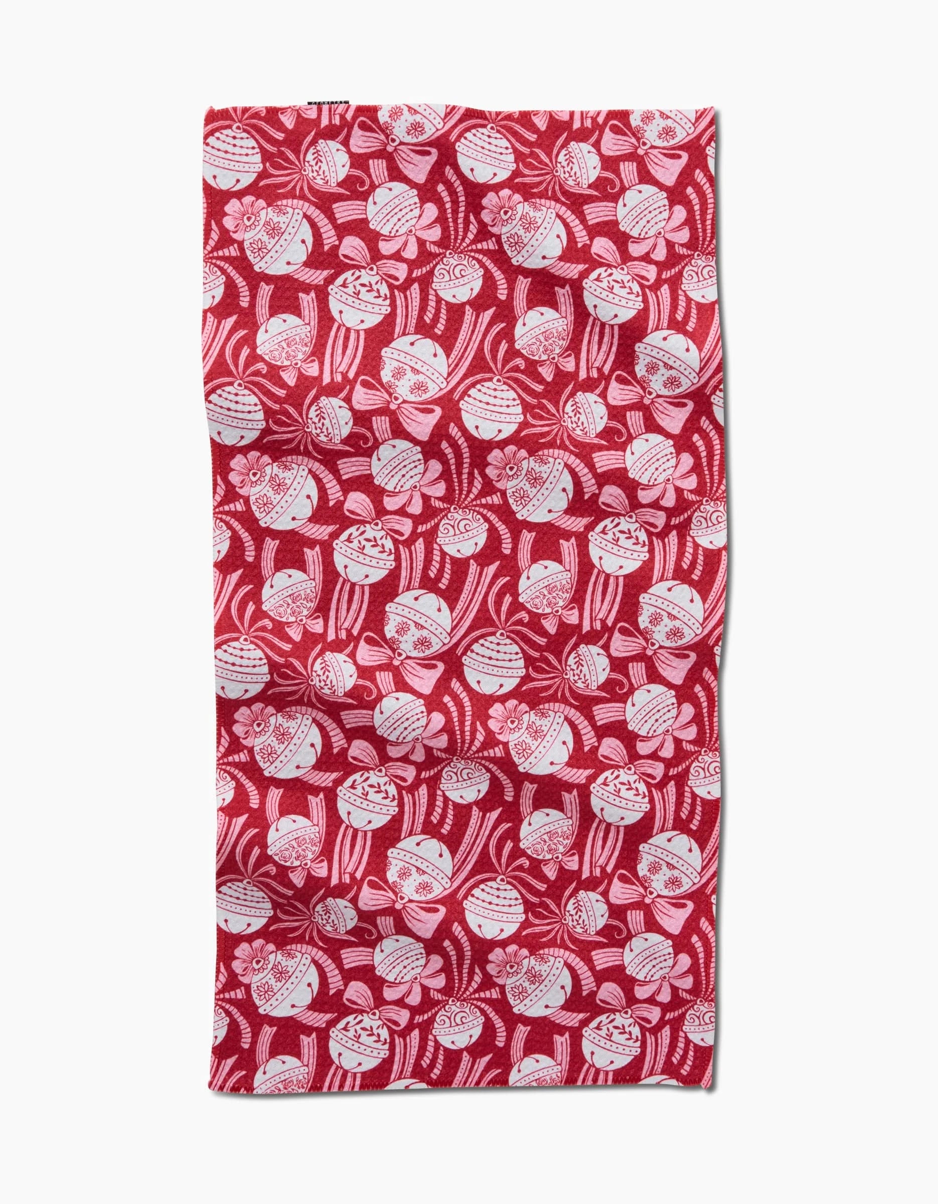 The Holiday Bells Bows kitchen towel by Sarah Daugherty is a rectangular red recycled towel, featuring a lively all-over print of white holiday bells and bows on a plain background.