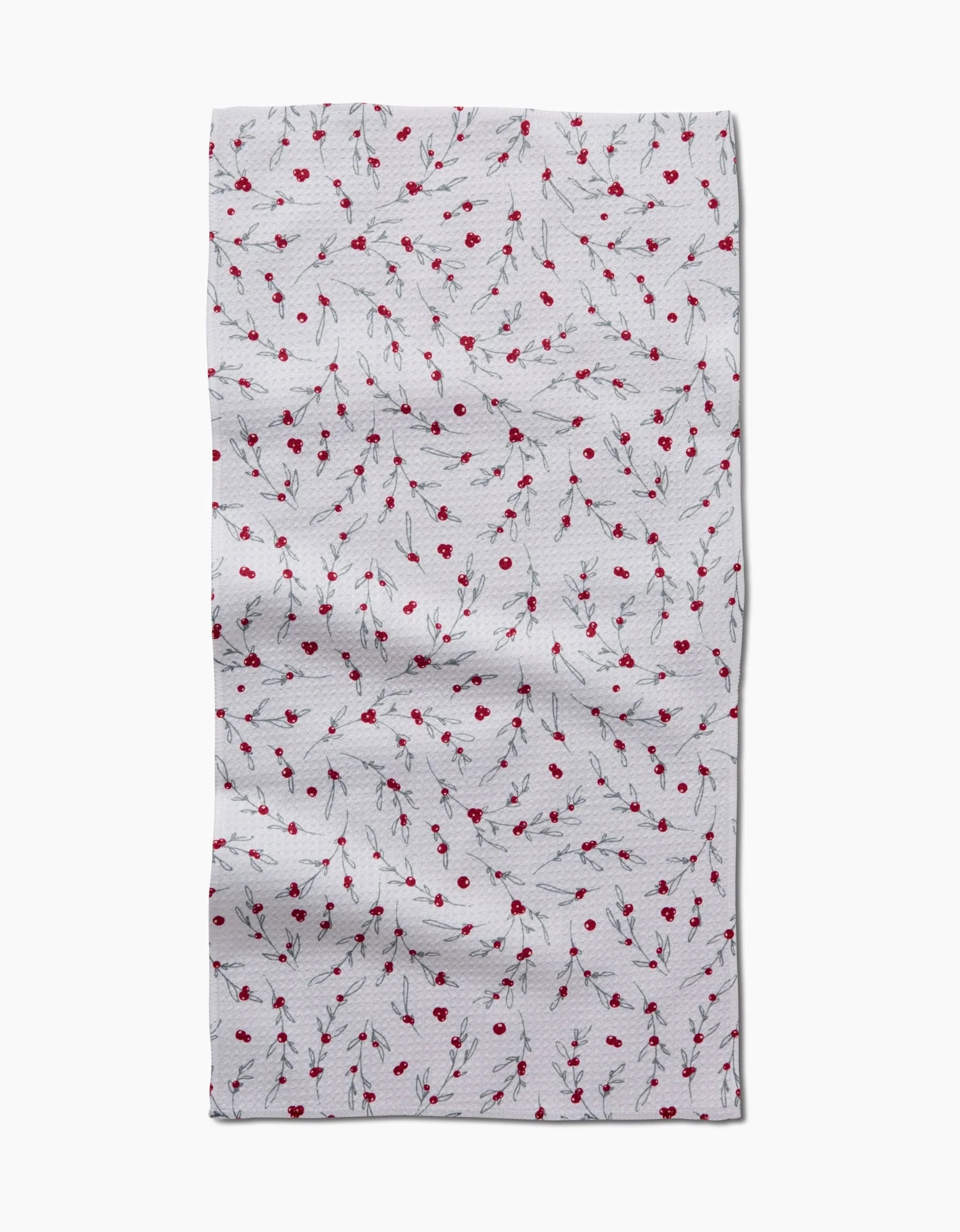 The Holiday Sprigs bar towel by Ashley Celena is a white, rectangular towel made from recycled materials, featuring small red flowers with thin black stems. It appears slightly wrinkled against a plain white background.