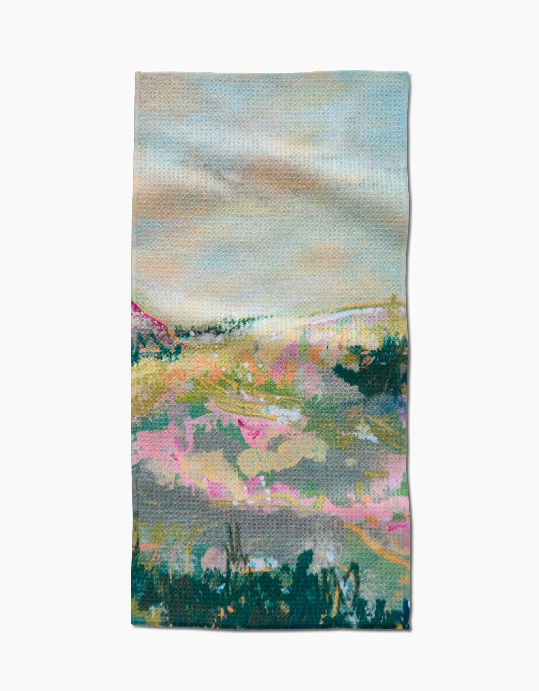 The Land of Milk and Honey Bar Towel by Taryn Brennan features an abstract landscape in soft pastel pinks, greens, and blues with hills and clouds. Made from Geoweave fabric for superior absorbency and durability.