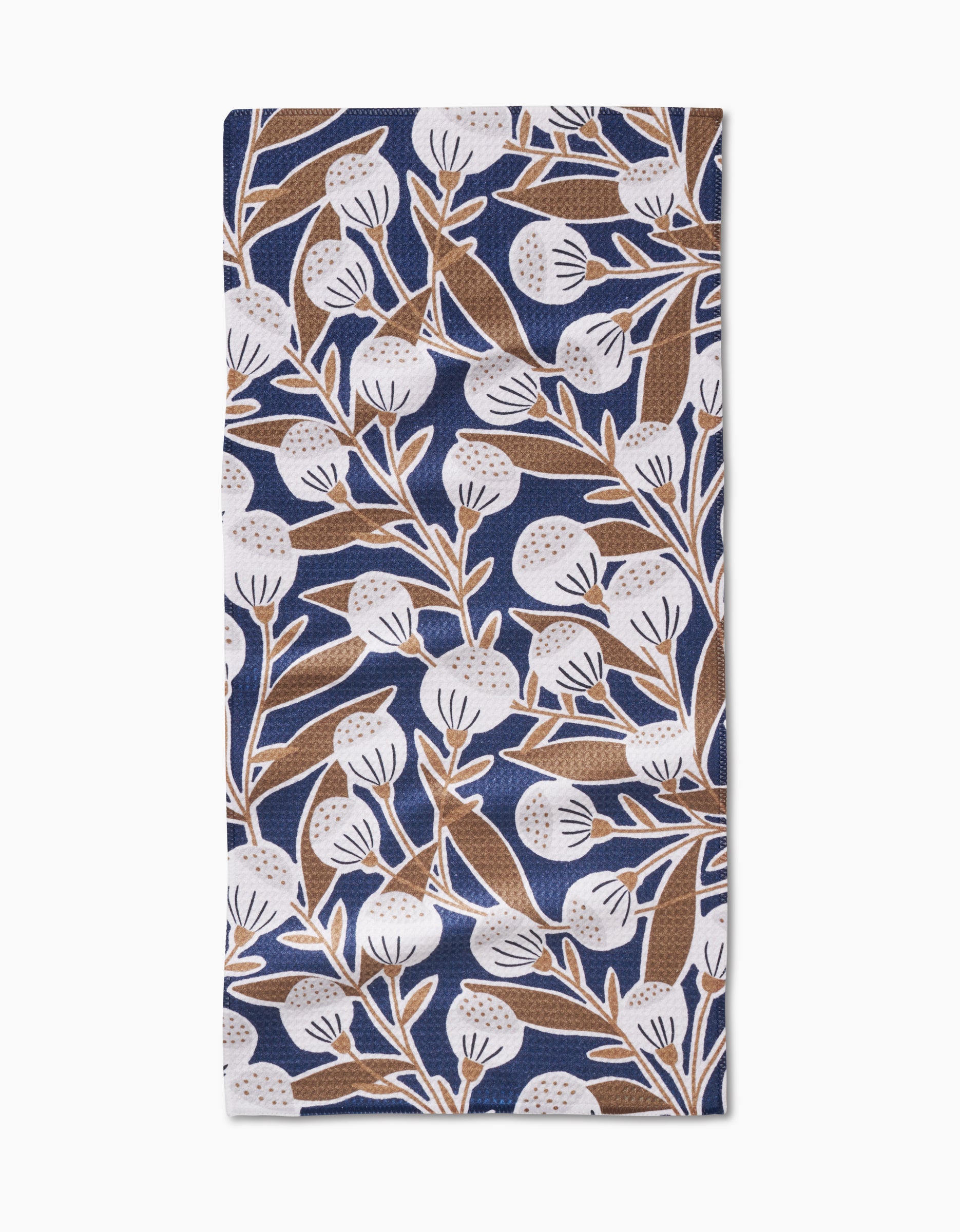 The Leslie napkin by Amy MacCready features ultra-absorbent Geoweave fabric with a blue background and a brown-and-white botanical design of leaves and round flowers.