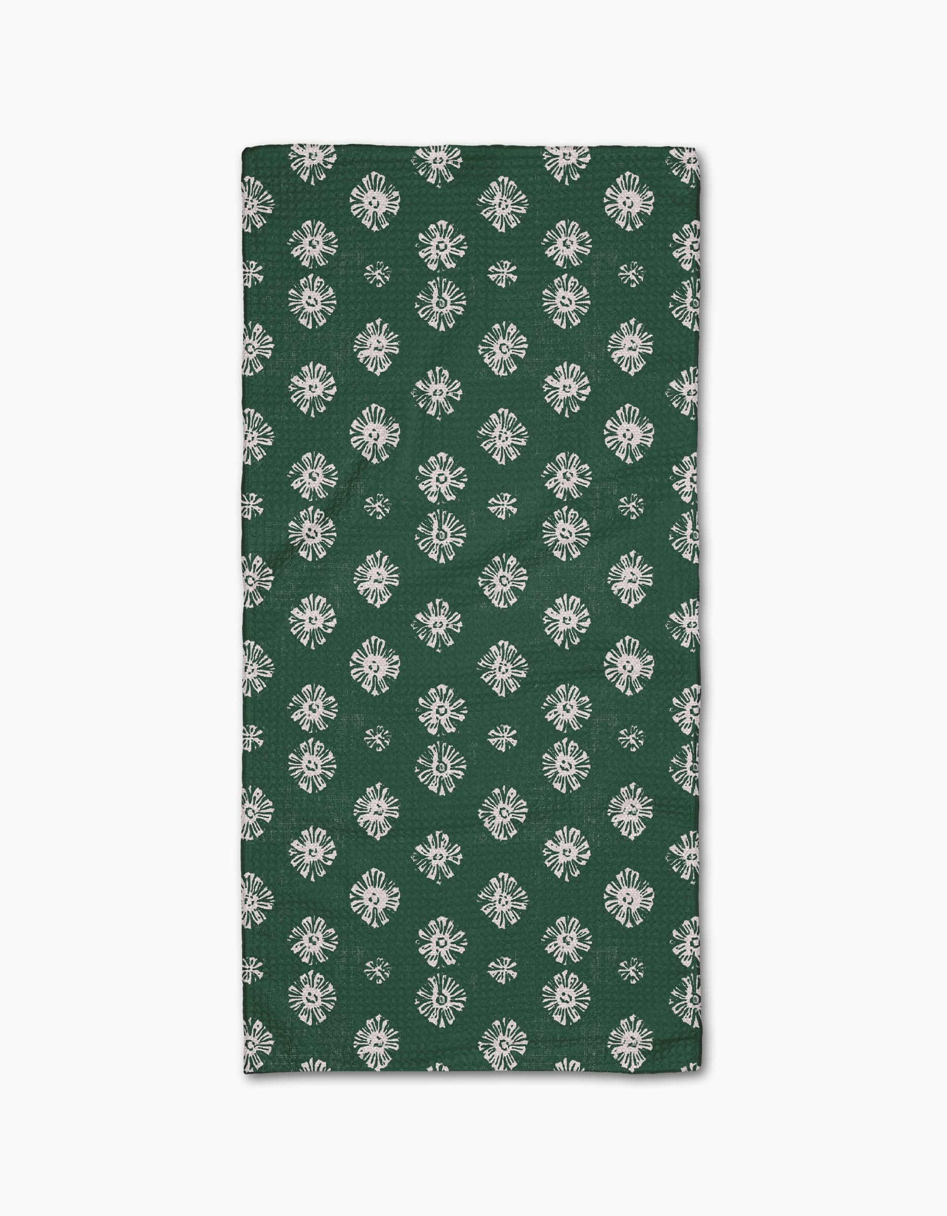 The Leyla Green napkin by Geometry features Geoweave fabric in dark green with a repeating white floral pattern, shown folded on a white background.