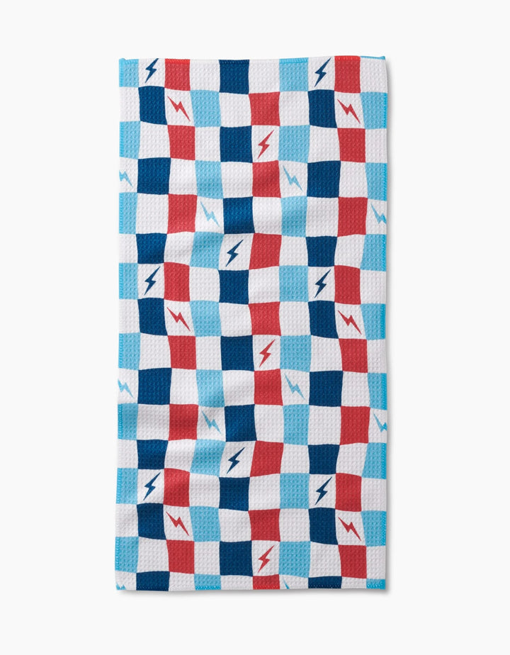 The Lightening Bolt Chess Bar Towel by Hufton Studio features a blue, red, and white checkered design with lightning bolts on Geoweave fabric, shown against a white background.