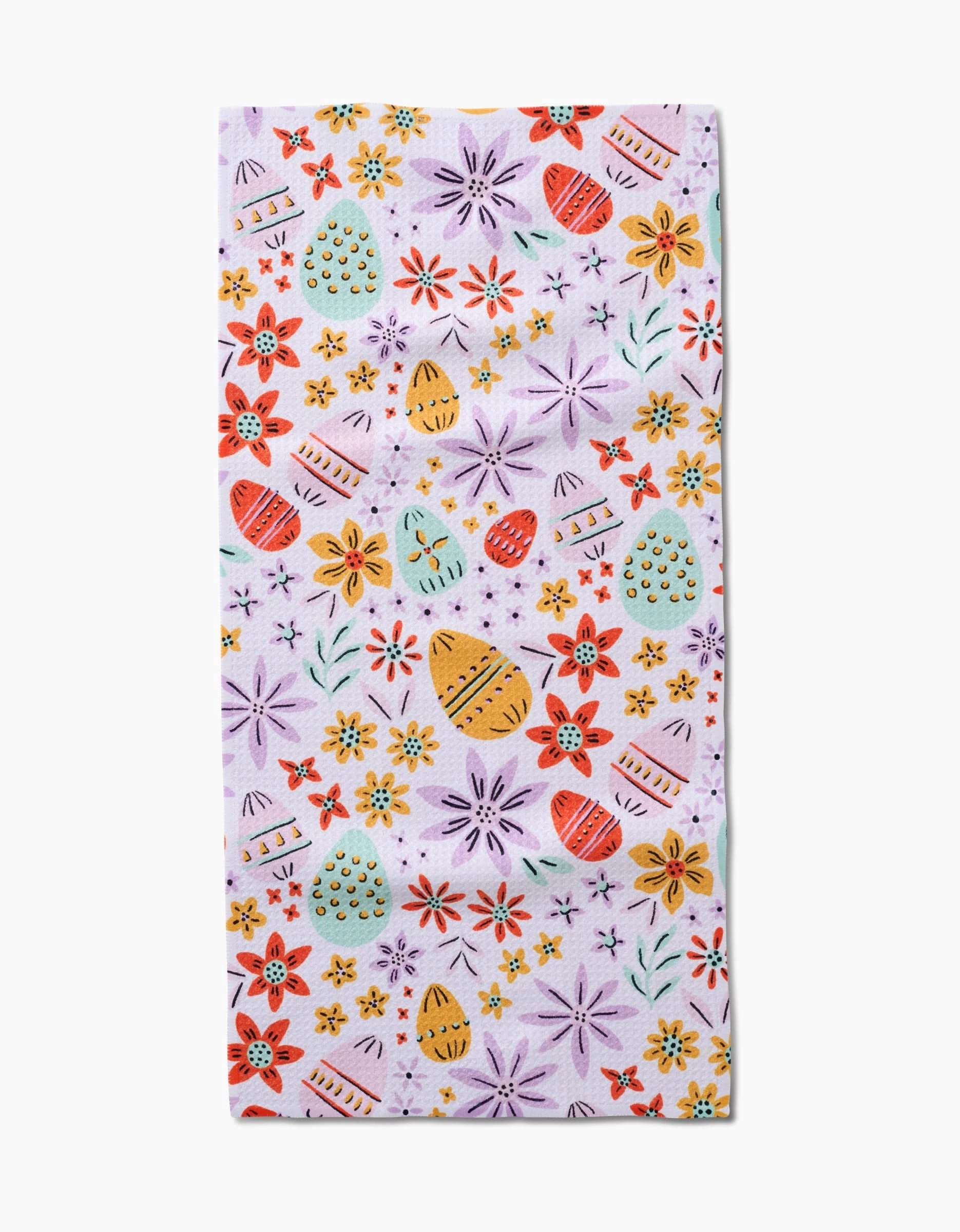 The Lilith towel by Amy MacCready is rectangular, ultra-absorbent, and features a pastel purple background with colorful Easter eggs and red, yellow, orange, and green floral patterns.
