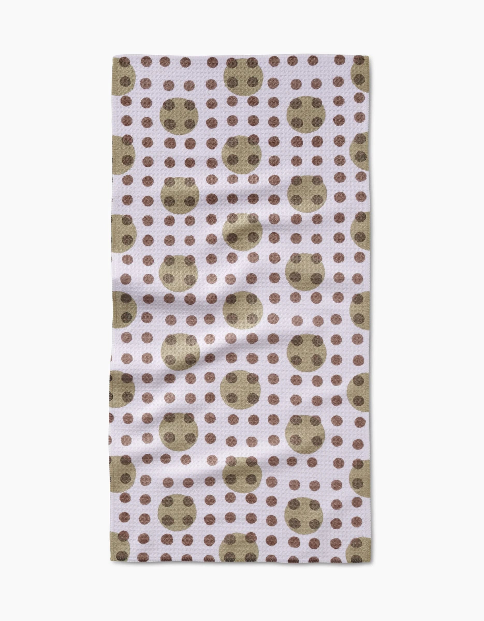 The Lotty Dotty Bar Towel by Studio Jeannot features large olive green dots with smaller brown dots on a light background, crafted from ultra-absorbent Geoweave fabric for superior drying.