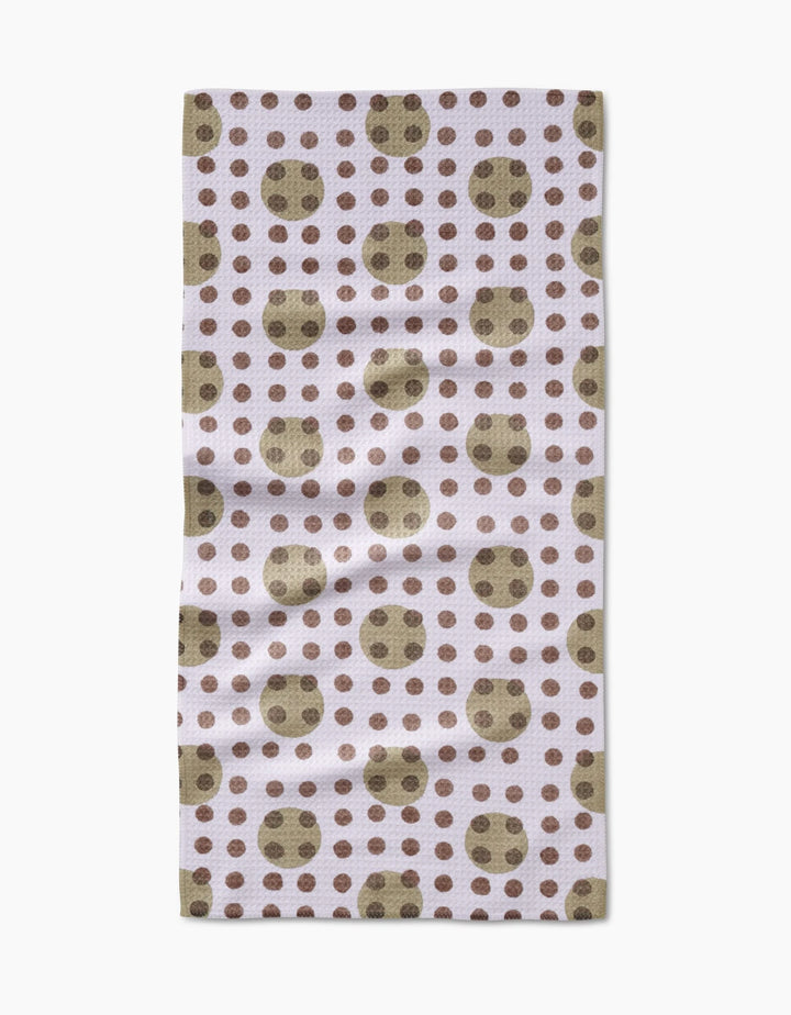 The Lotty Dotty Bar Towel by Studio Jeannot features large olive green dots with smaller brown dots on a light background, crafted from ultra-absorbent Geoweave fabric for superior drying.