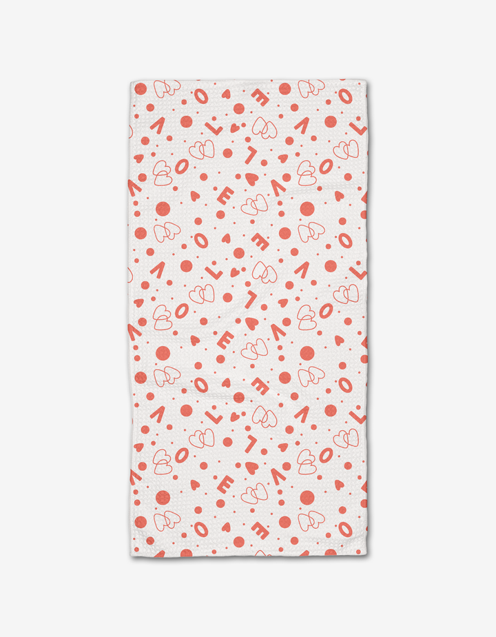 The “Love Party” bar towel from Charlie Rowan Designs is ultra-absorbent, white, and features a playful pattern of red hearts, dots, and scattered “LOVE” lettering.